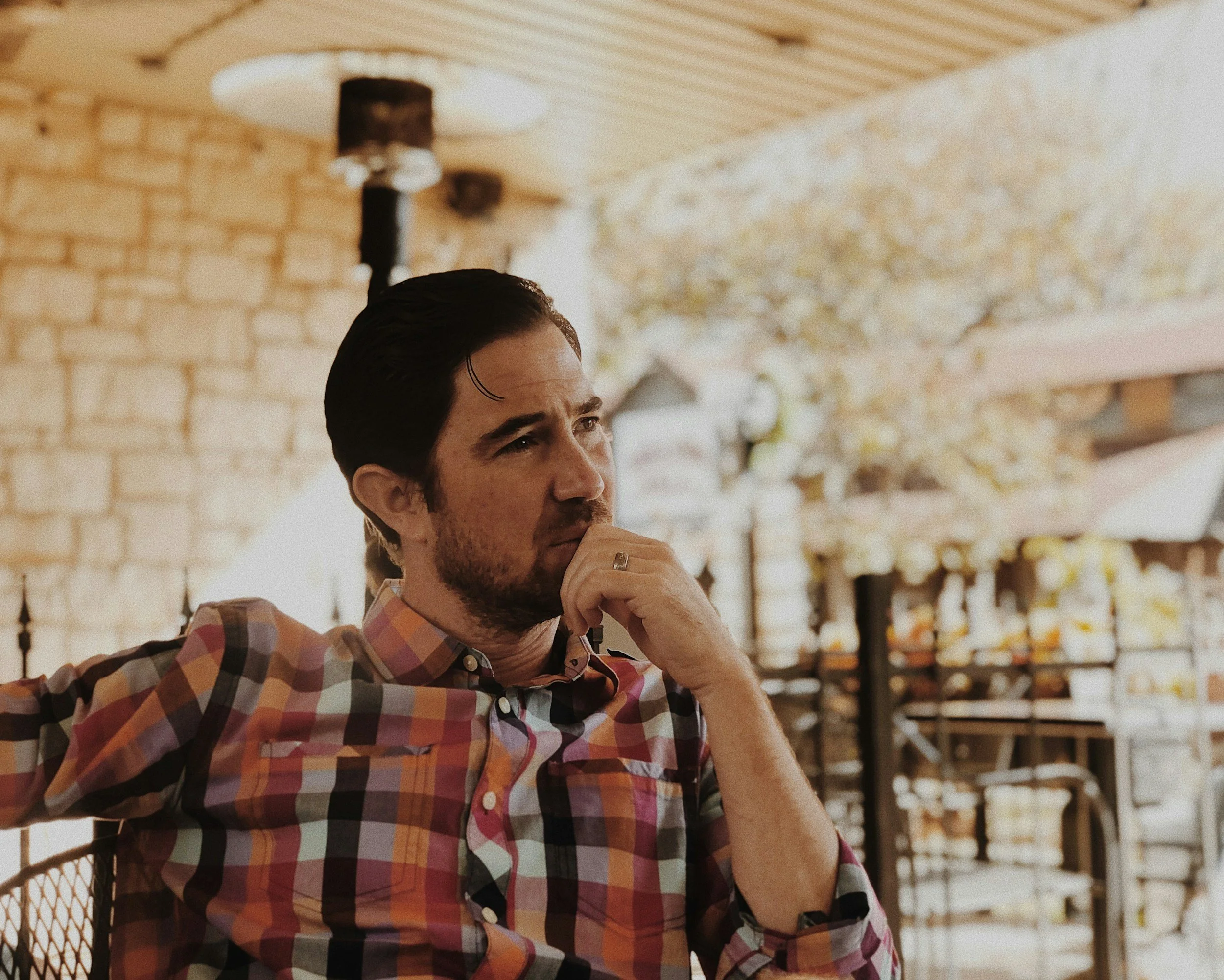 Reflective man sitting outdoors representing stress management and emotional wellness.