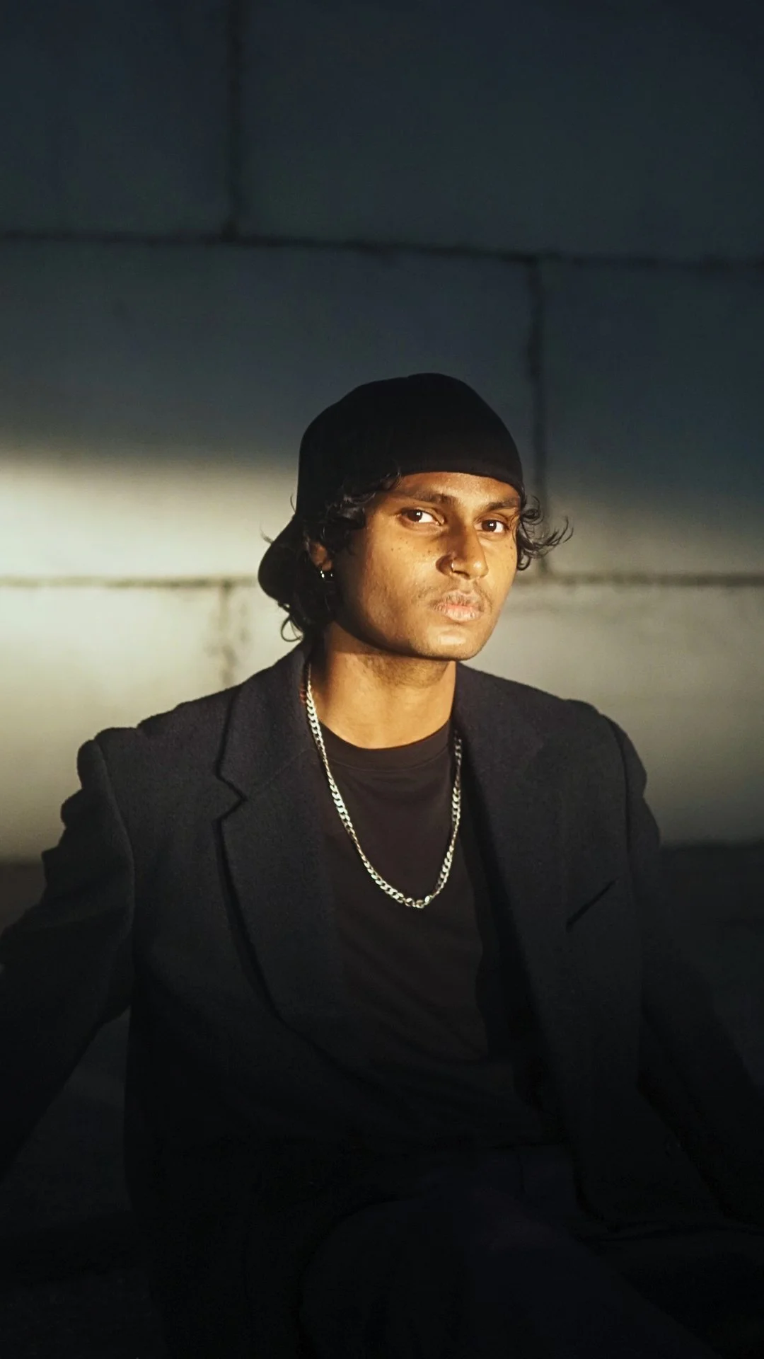 photo of a young man wearing a black shirt and black hat