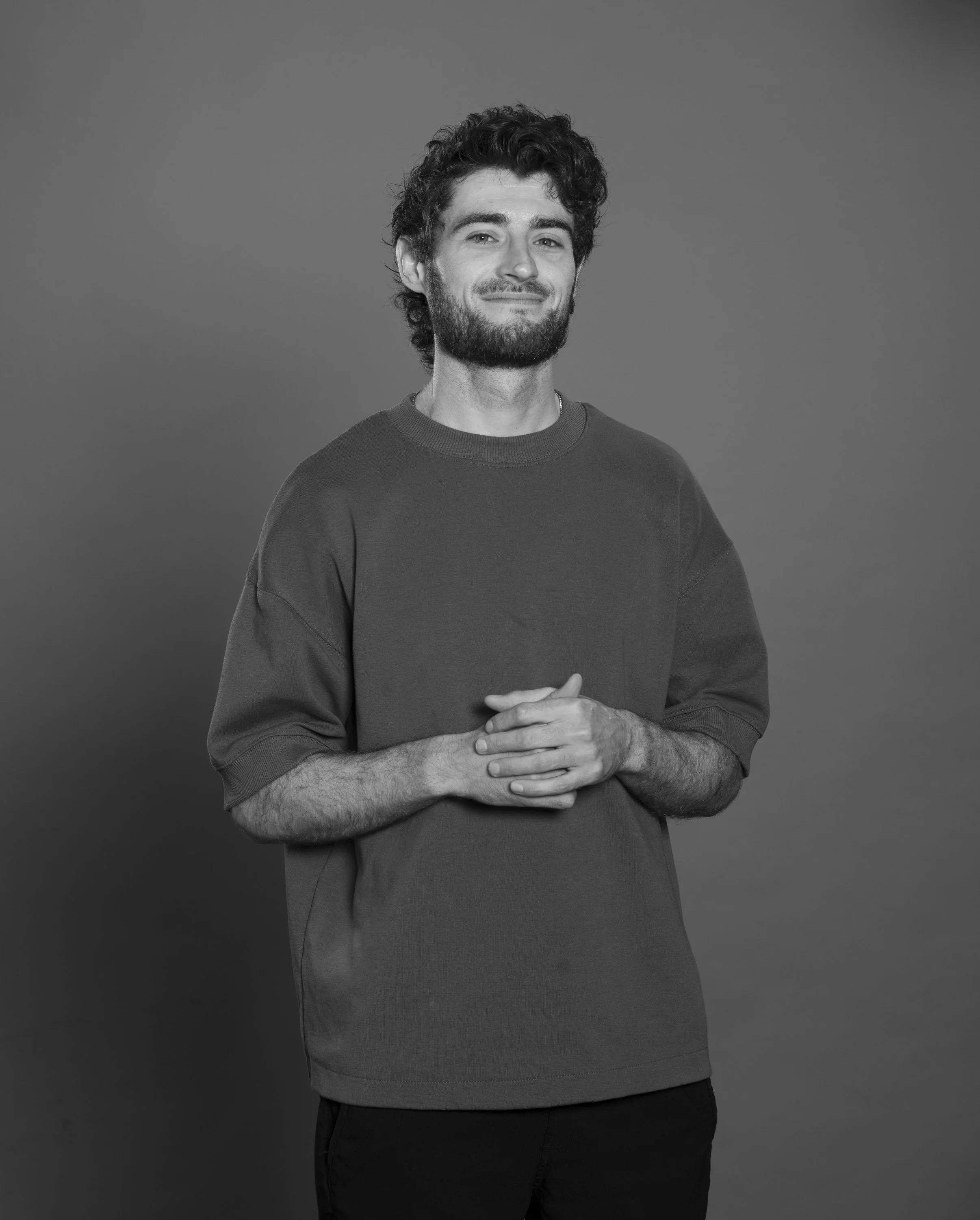 image of a young man holding his hands together and looking at the camera
