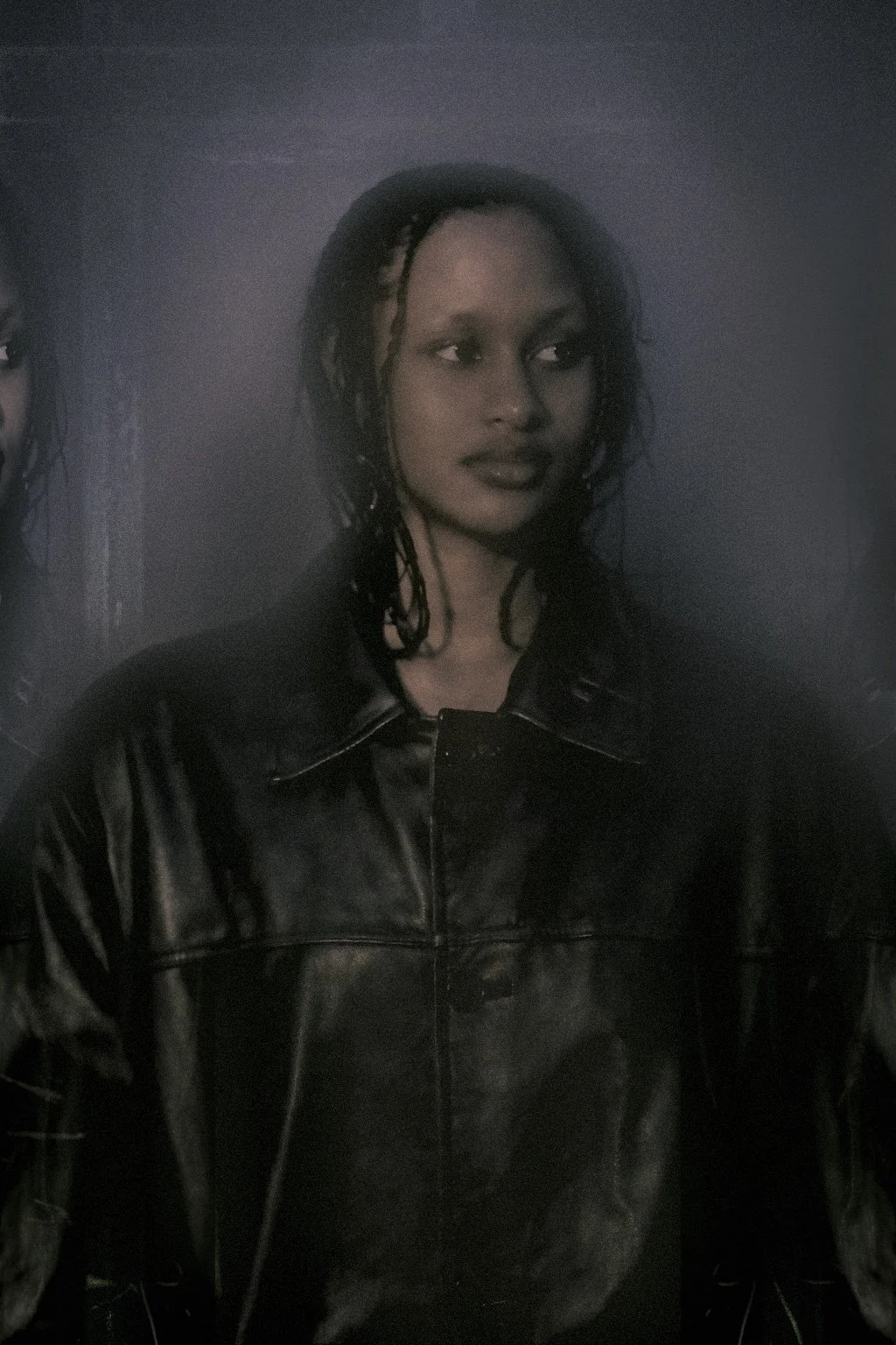 photo of a young lady with dreadlocks looking over her shoulder to the left