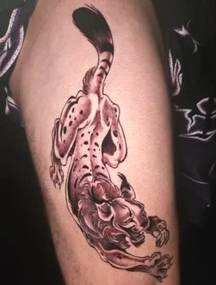 Tropical fish swimming in water tattoo on person's upper arm.