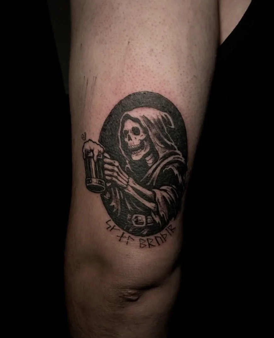 Tattoo of a skeleton with a hood holding a beer mug, with runic symbols and the words 'Seize the Bard' beneath.