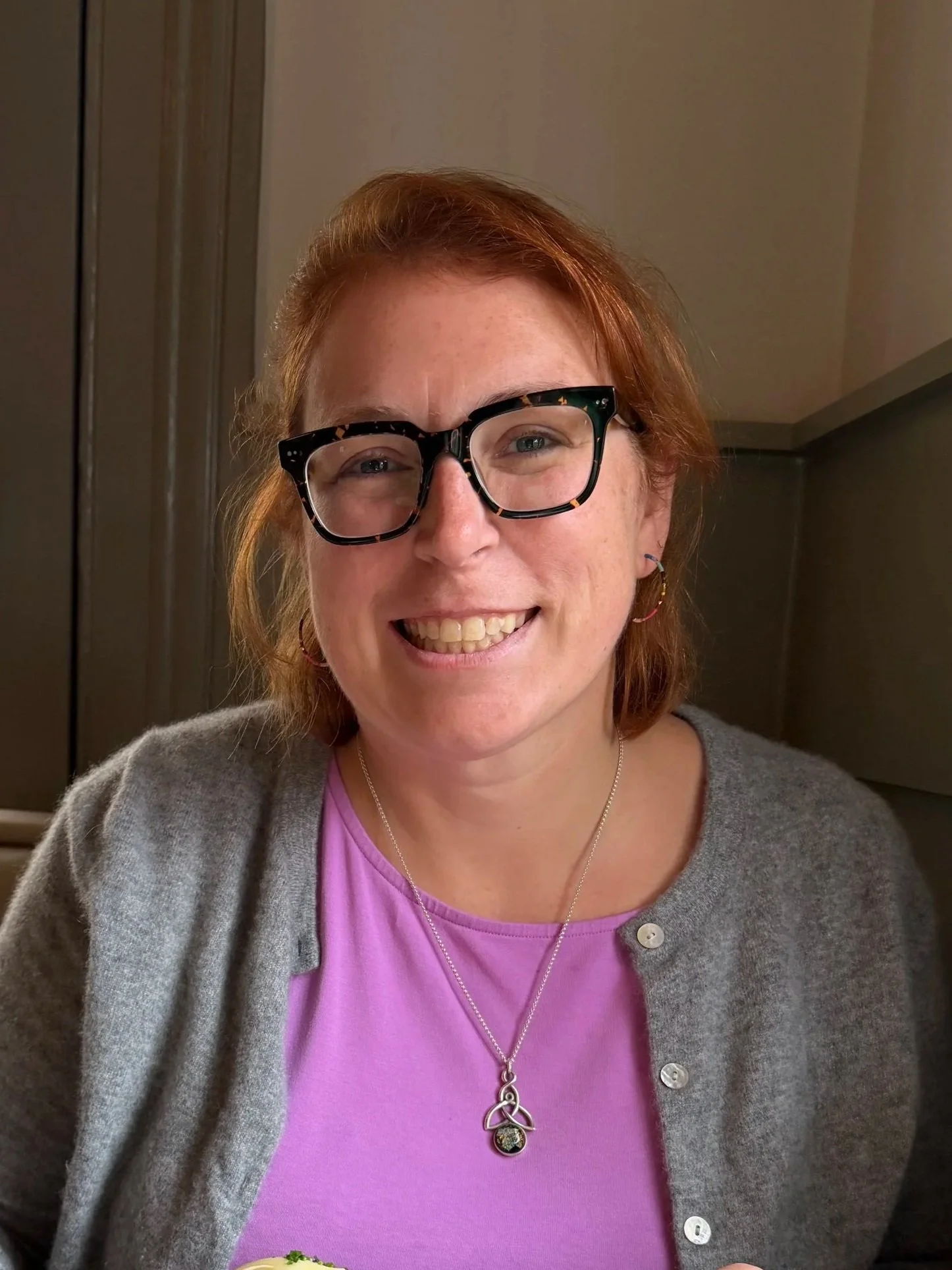Sarah Schufreider, LCSW, smiling in a grey cardigan — online therapist in Chicago, Illinois specializing in menopause and postpartum support
