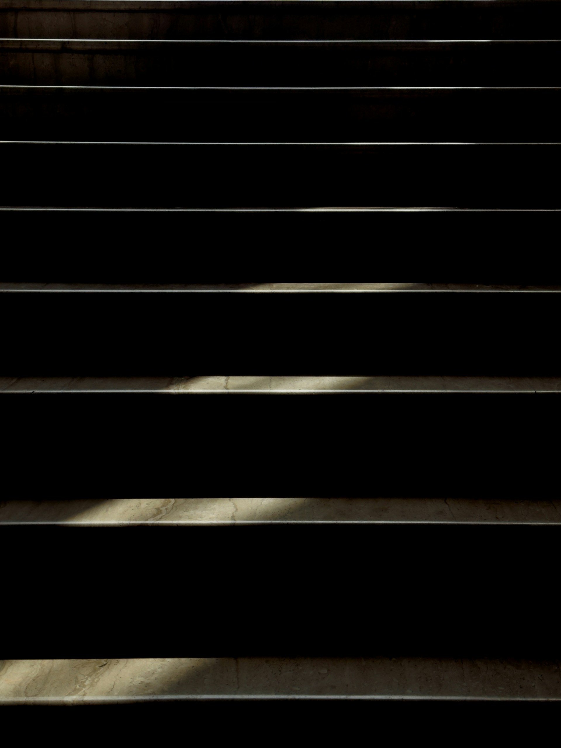 Image of black metal stairs from below, showing the steps with some visible dirt and wear.