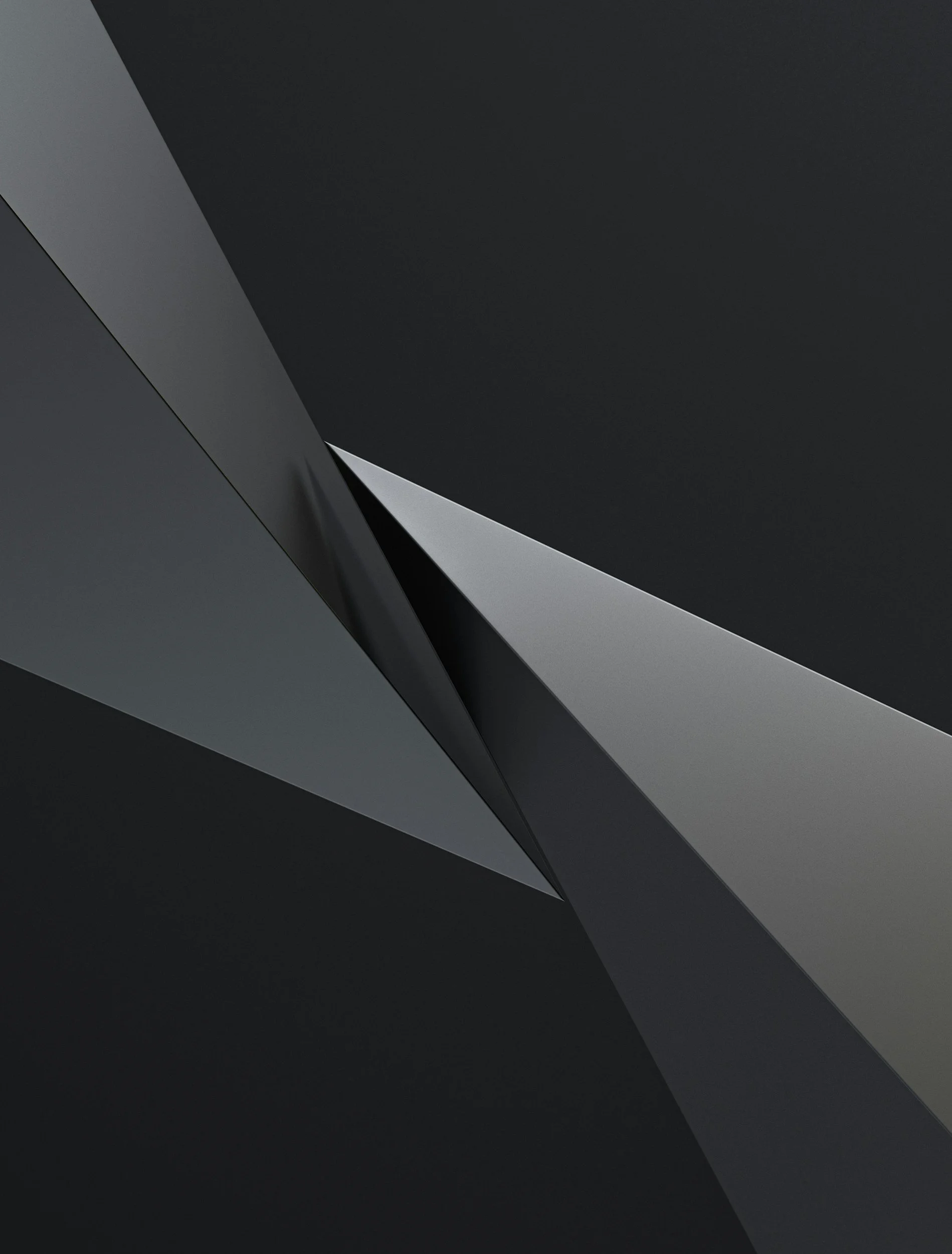 Close-up of a black geometric surface with angular shapes and shadows, creating a sleek, modern appearance.