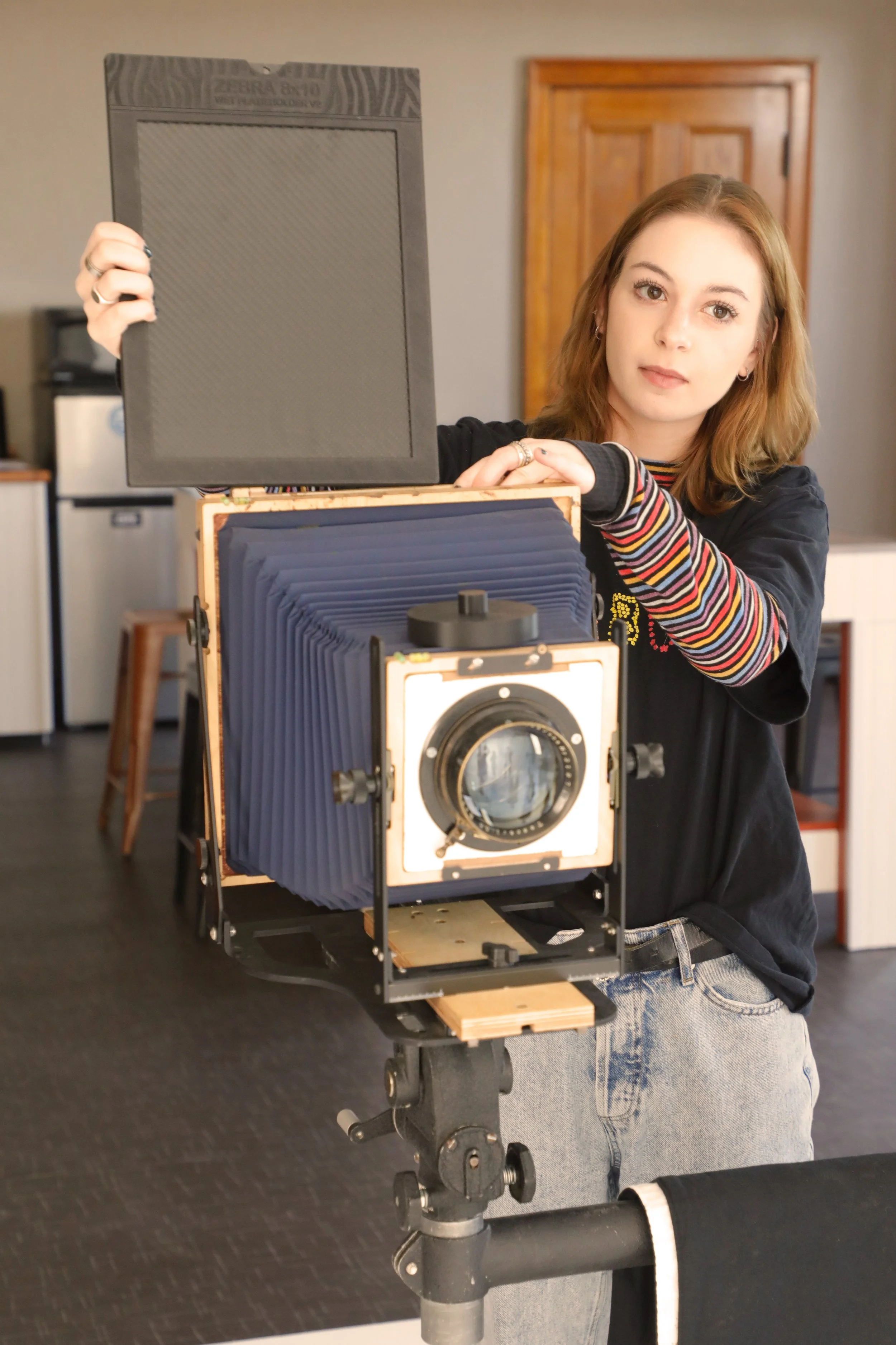 Niagara Falls NY near Buffalo NY, in a rentable photo studio, A young woman uses a large format 8x10 camera to take a photograph.