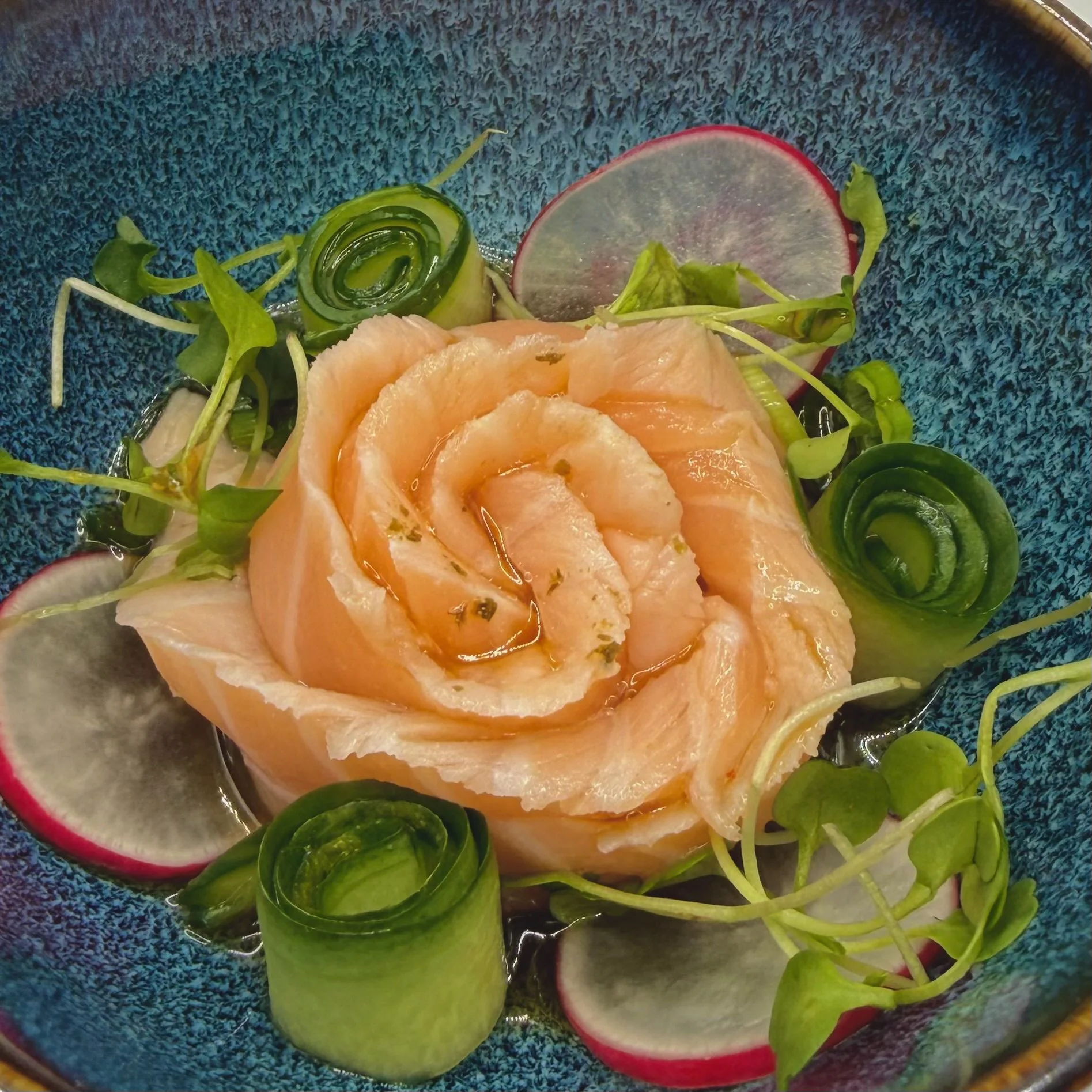 Precision-carved Atlantic salmon petals arranged in a stunning rose presentation, marinated in a citrus-ponzu. Accompanied by cucumber ribbons and wafer-thin radish for an elegant, garden-inspired masterpiece. 