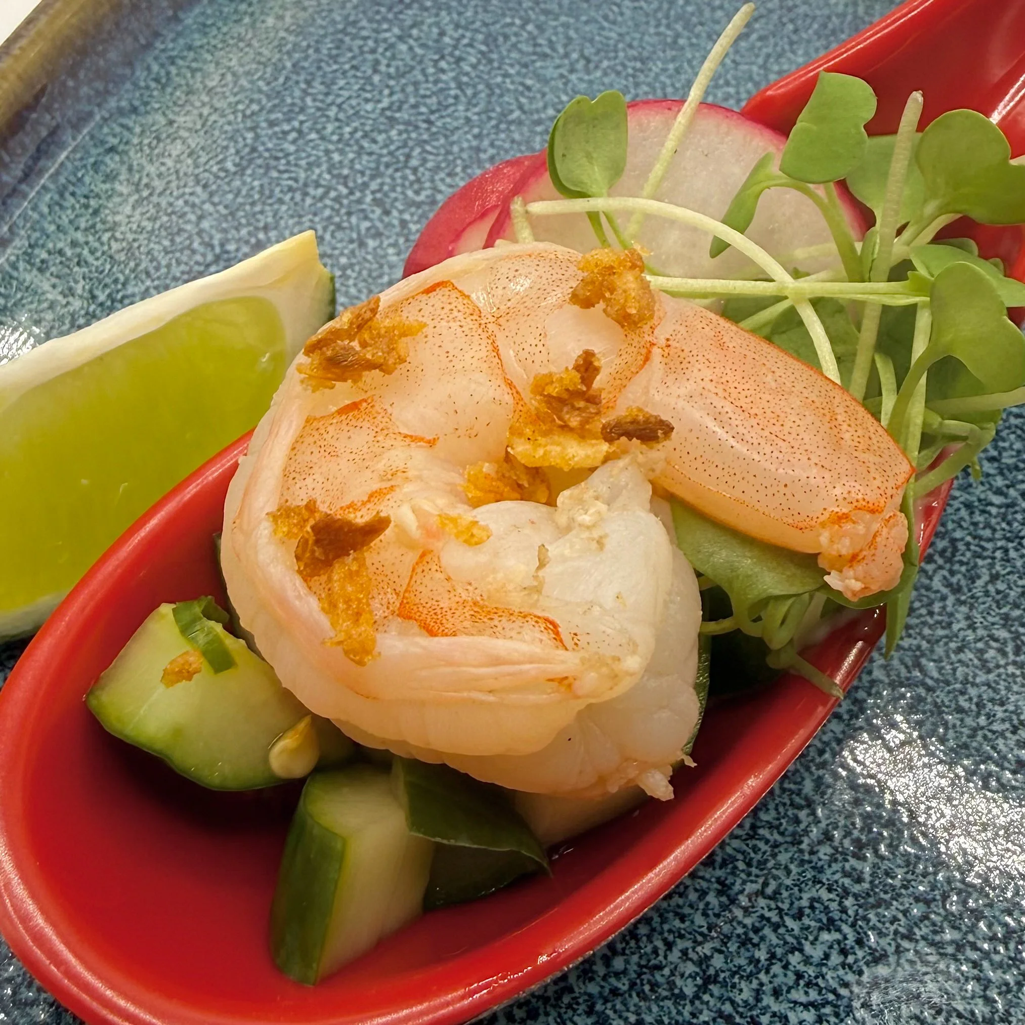 Chilled jumbo shrimp resting on a crisp cucumber salad tossed in a bright chili-lime vinaigrette. Finished with toasted garlic crunch and fresh micro-greens.