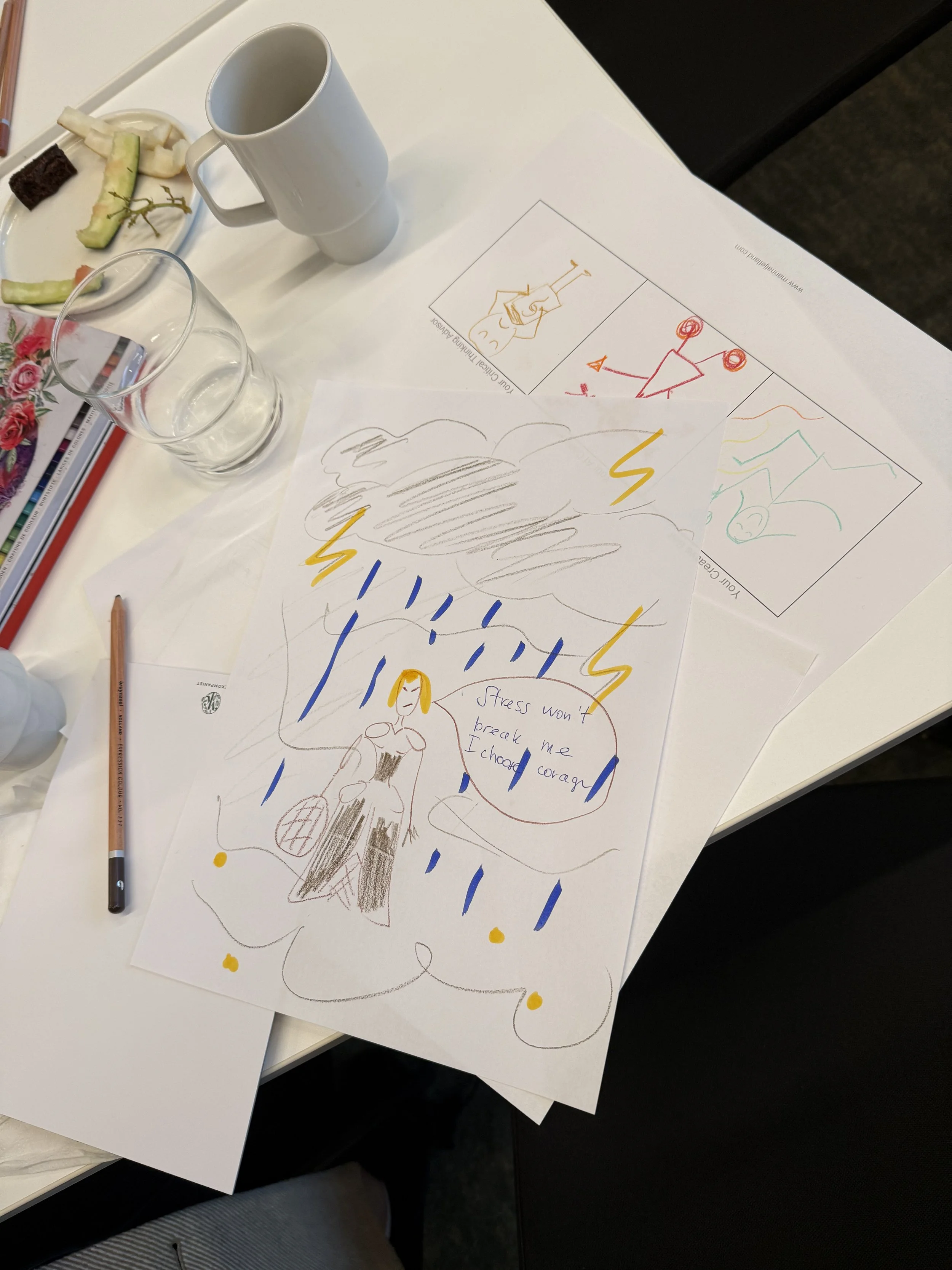 Hand-drawn sketches and notes on a white sheet of paper, including a person with a speech bubble saying 'Stress won't break me, I choose...' and symbols of thunderstorms, lightning bolts, and rain, on a white table with a mug, glasses of water, and a