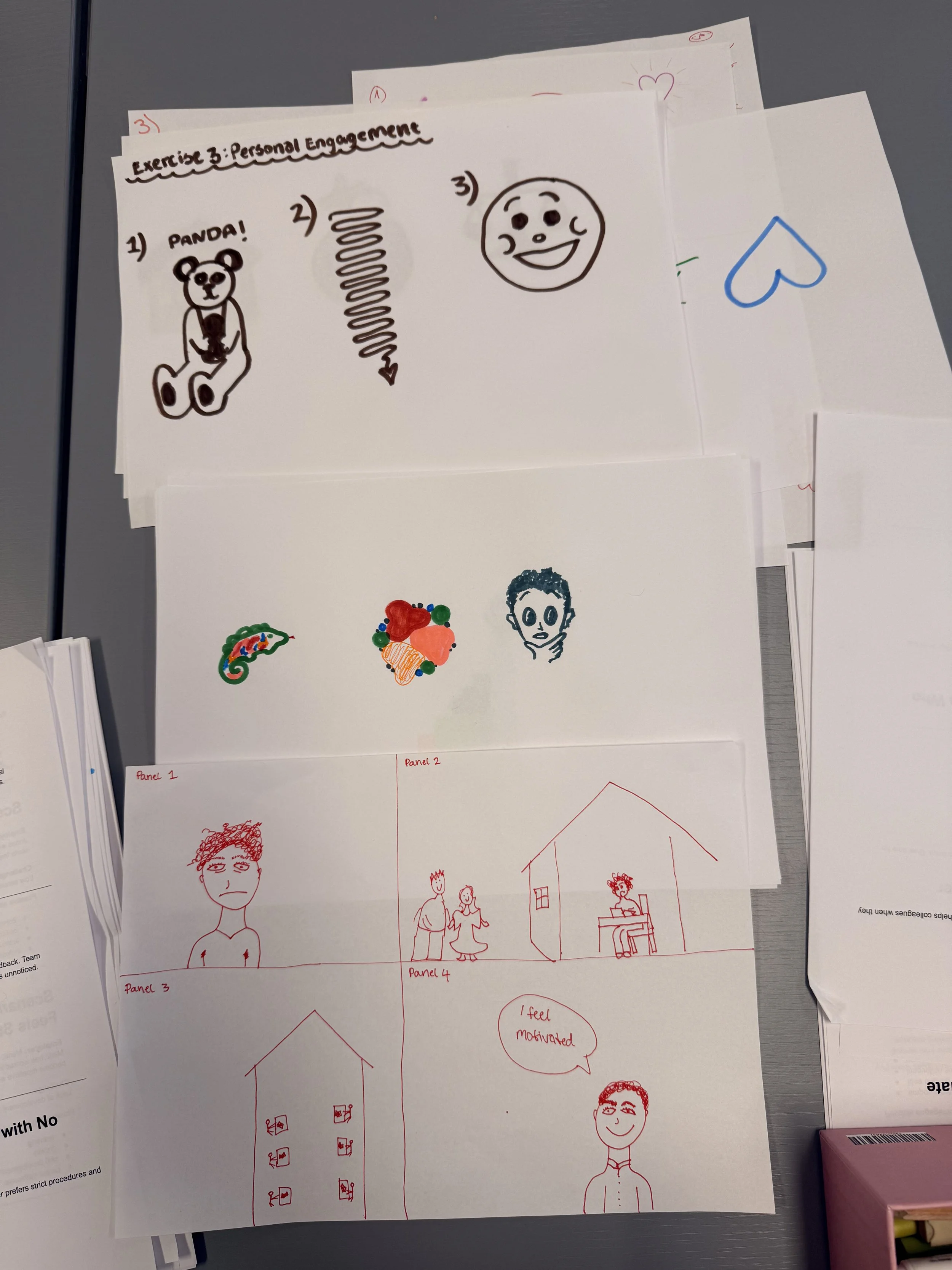 A collection of hand-drawn sketches on paper sheets organized into panels, including a panda, a swirl arrow, a smiling face, a house, people, and motivational notes.
