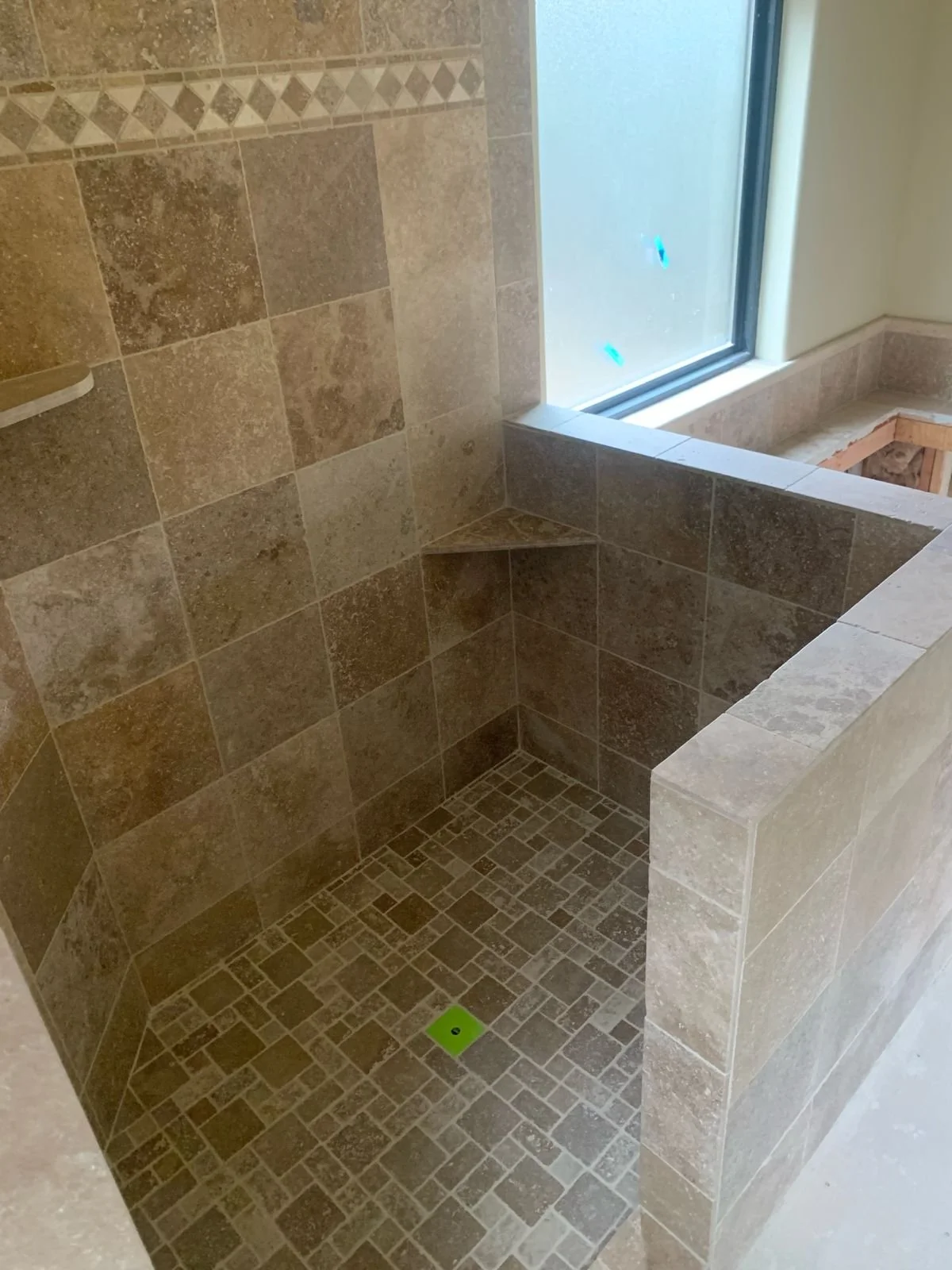 tiled_shower_floor_shampoo_shelves_half_wall_tile.jpeg
