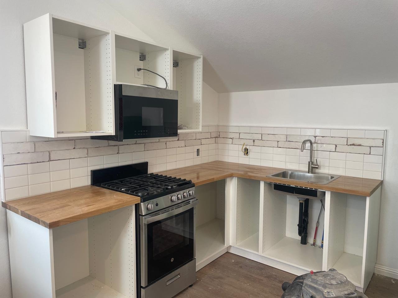 Kitchen backsplash installation featuring white subway tile with natural wood countertops during a custom kitchen remodel in the Lake Tahoe area.