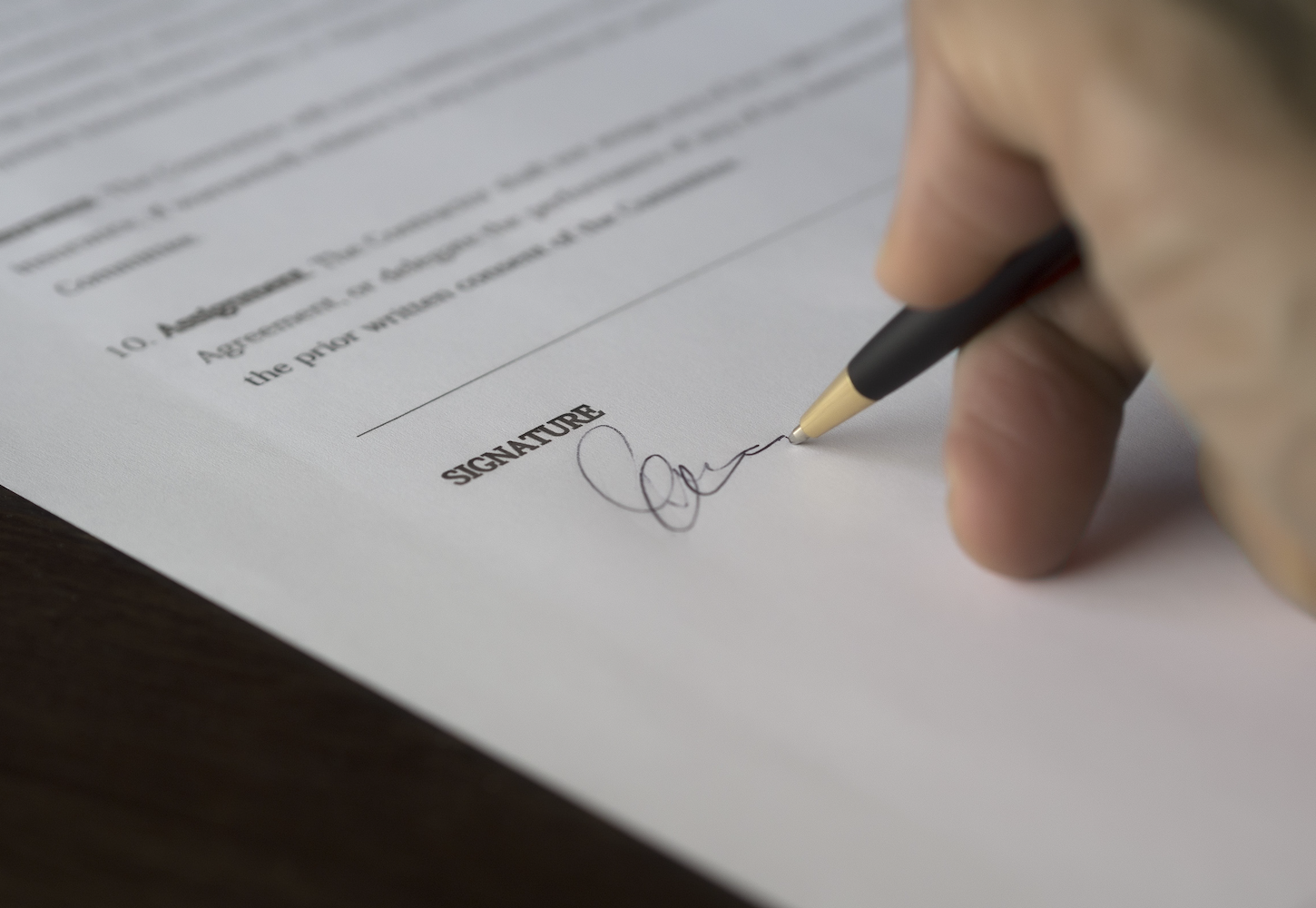 A hand signing a document, representing mobile notary services in San Francisco