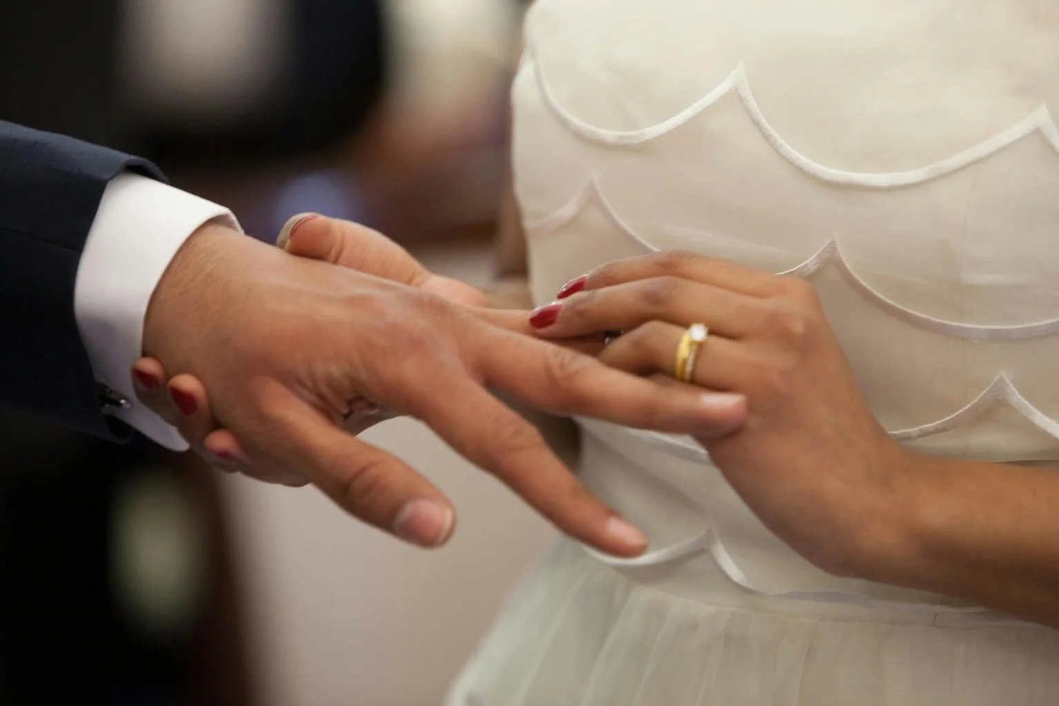 A bride putting a ring on a groom's finger, representing a certified copy of an Alameda County marriage certificate