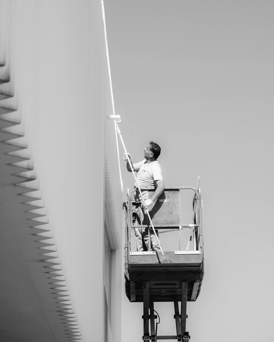 Painter rolling paint on a building exterior for a local service business.