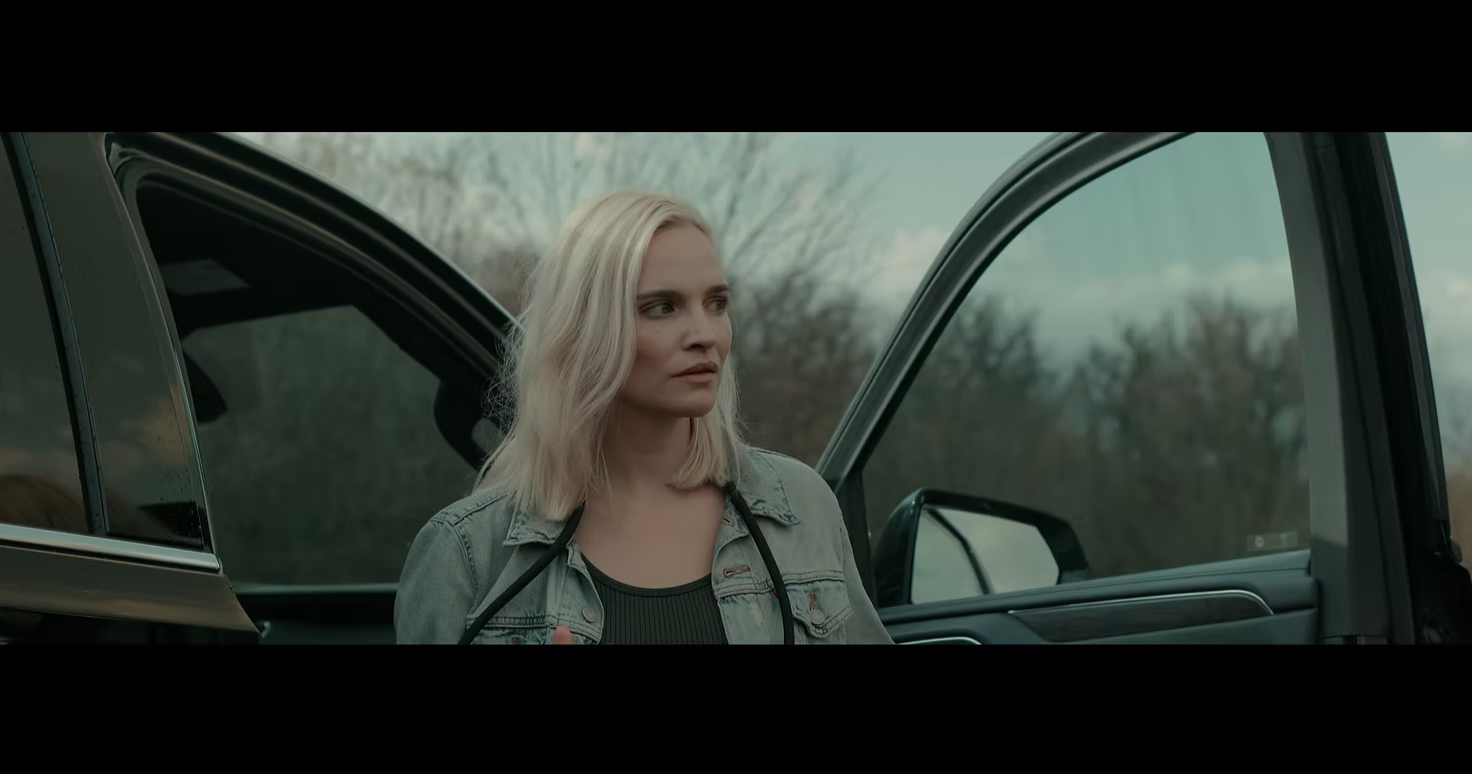 A blond actress by a car