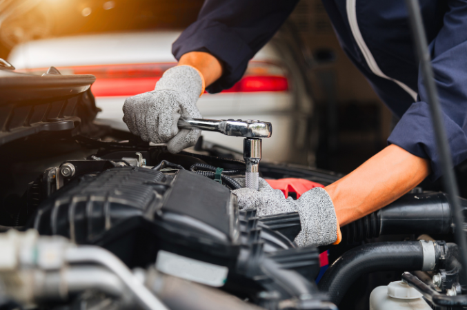 Person wearing work gloves, fixing engine
