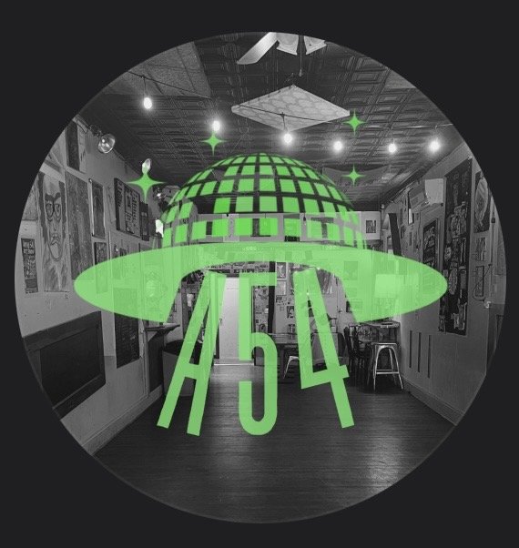 Green alien spaceship illustration with the number 54 in front, displayed in a black and white room decorated with various posters.