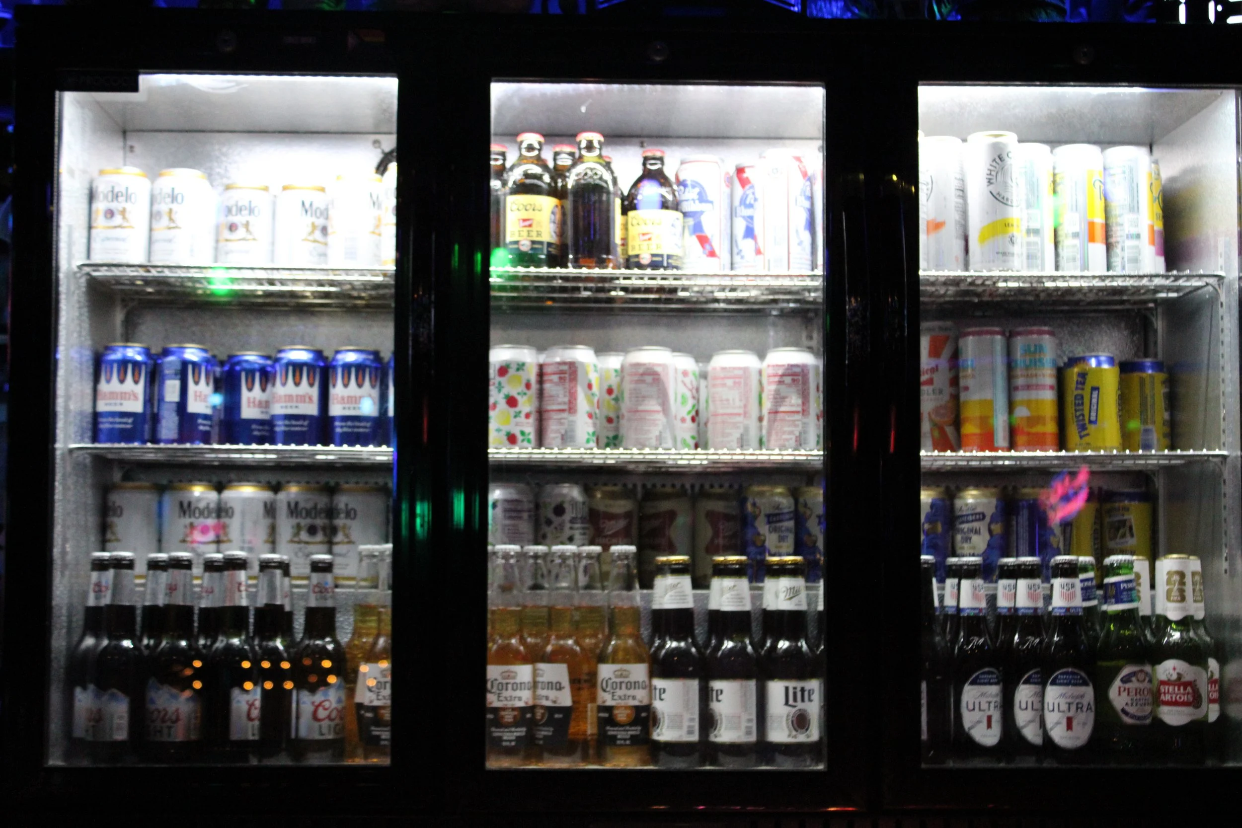 A refrigerator stocked with various canned and bottled beverages, including beer, soda, and energy drinks, in a store or bar setting.The Easy Inn Kansas Citys best kept secret underground dive bar serving great bar food