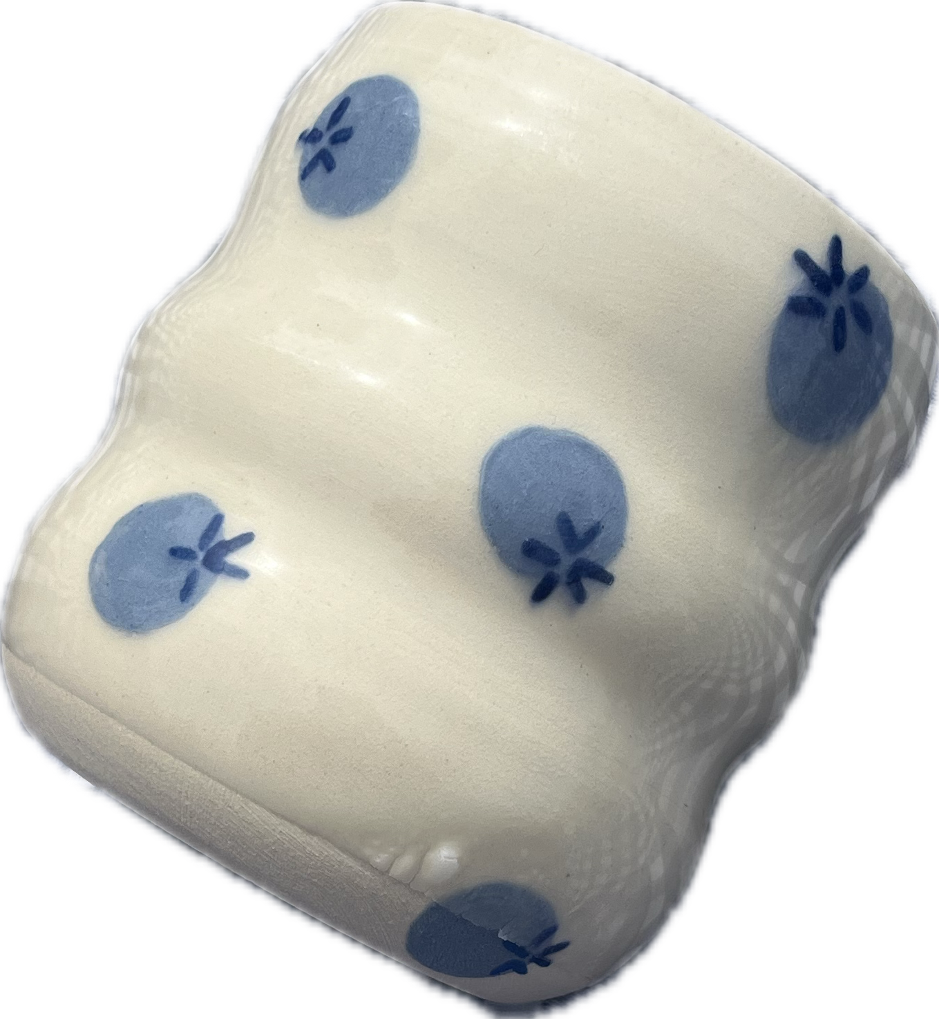 A white ceramic dice with blue strawberry patterns.