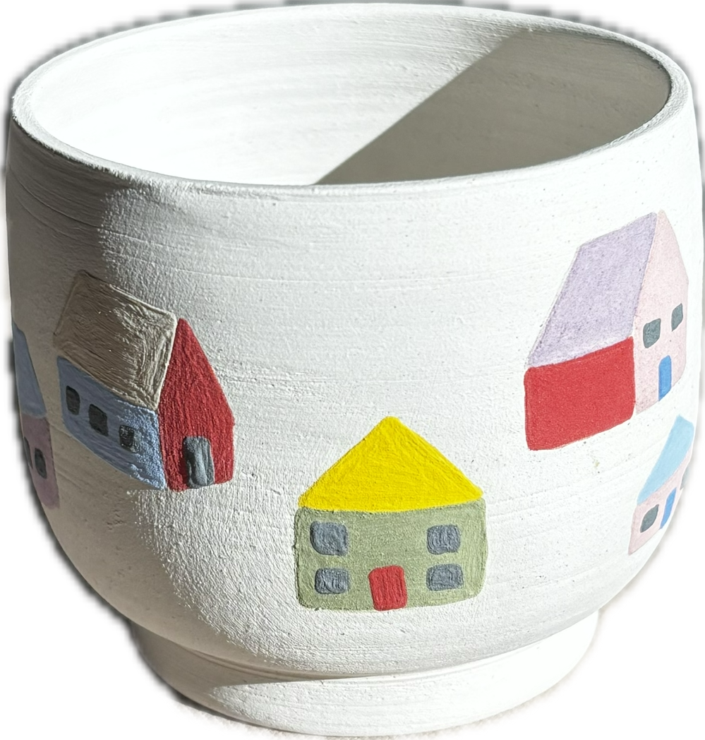 Hand-painted ceramic bowl featuring colorful house illustrations including a yellow-roofed house, a red house, and a gray house with a purple roof.