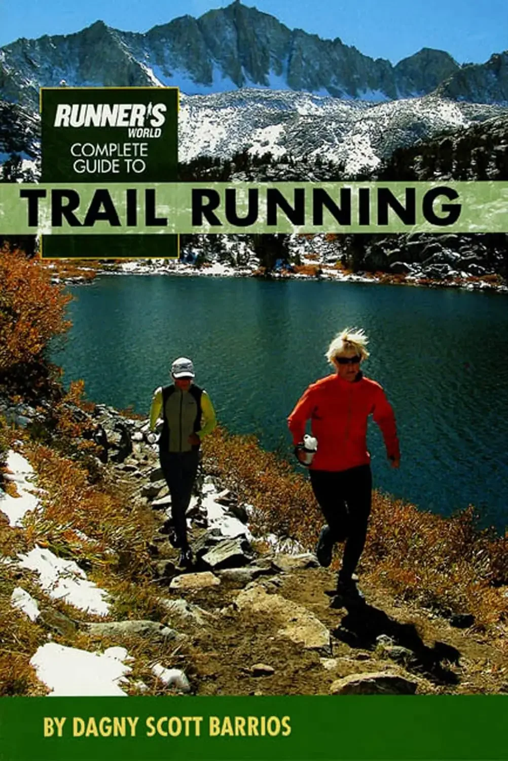 Cover of a book titled 'Runner's World Complete Guide to Trail Running' by Dagny Scott Barrios, showing trail runners hiking along a rocky trail next to a lake with mountains and snowy peaks in the background.