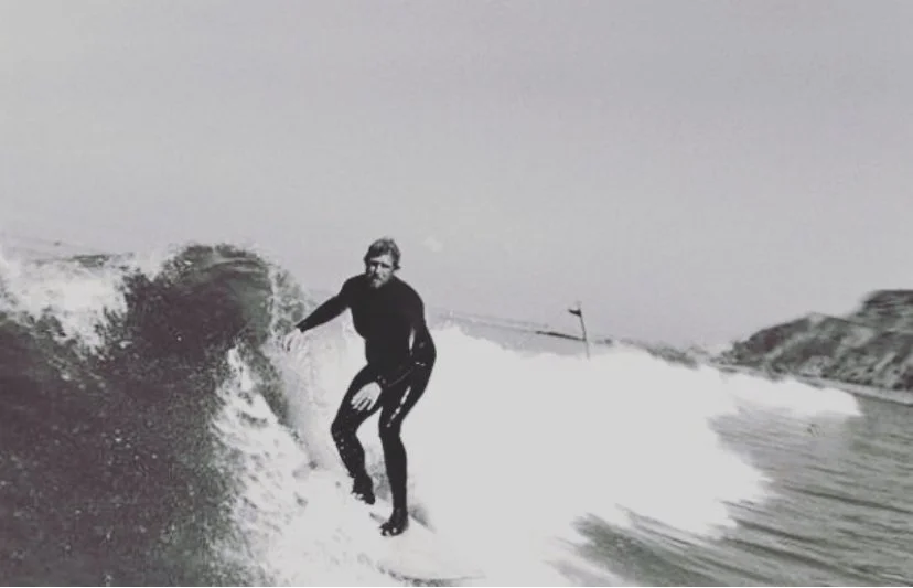 A person wearing a wetsuit surfing on a wave in the ocean.
