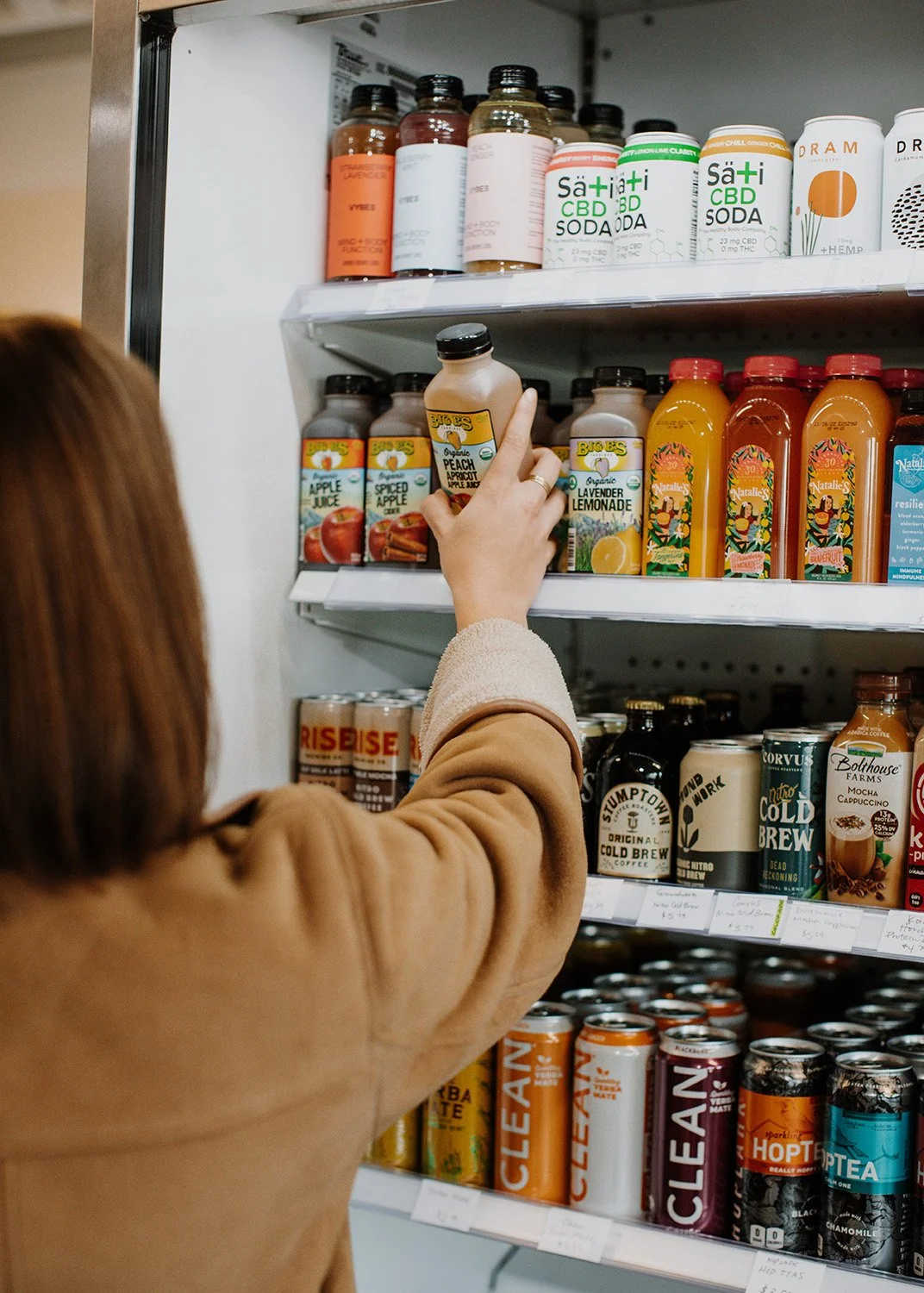 Woman grabbing a drink out of the drink cooler.