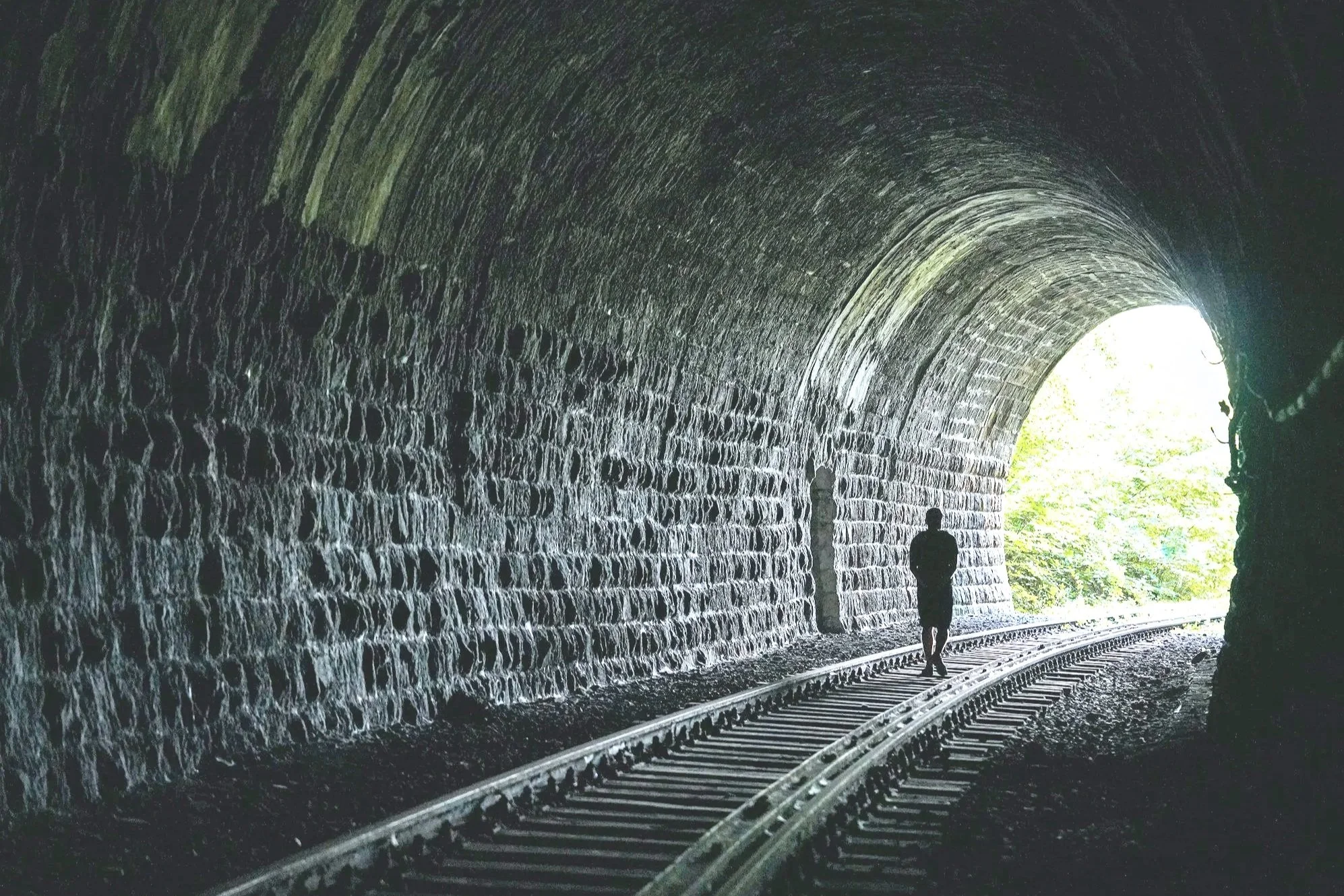 Image of a man on traintracks in a tunnel, symbolizing the hope and understanding that first responders experience in confidential therapy
