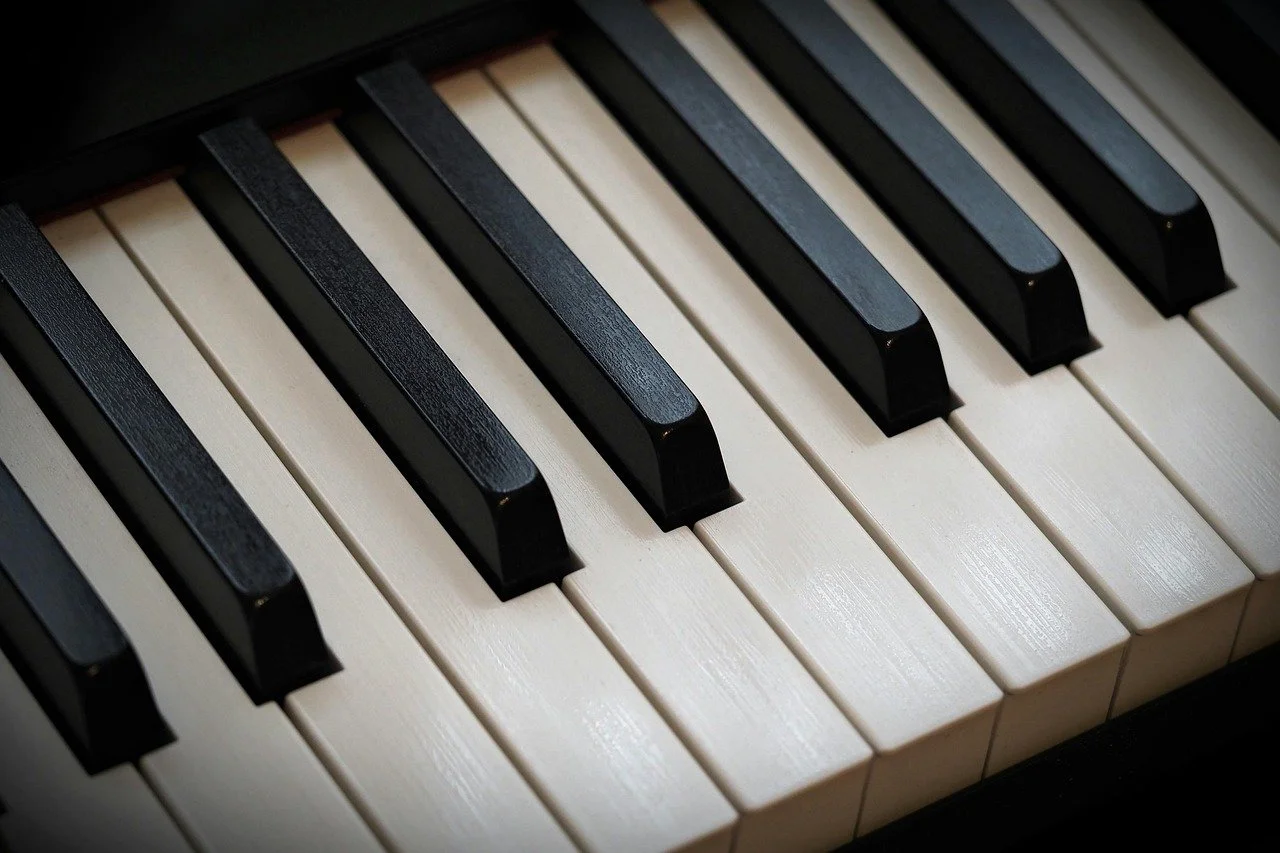 Close-up of piano keys, showing black and white keys in a musical instrument.