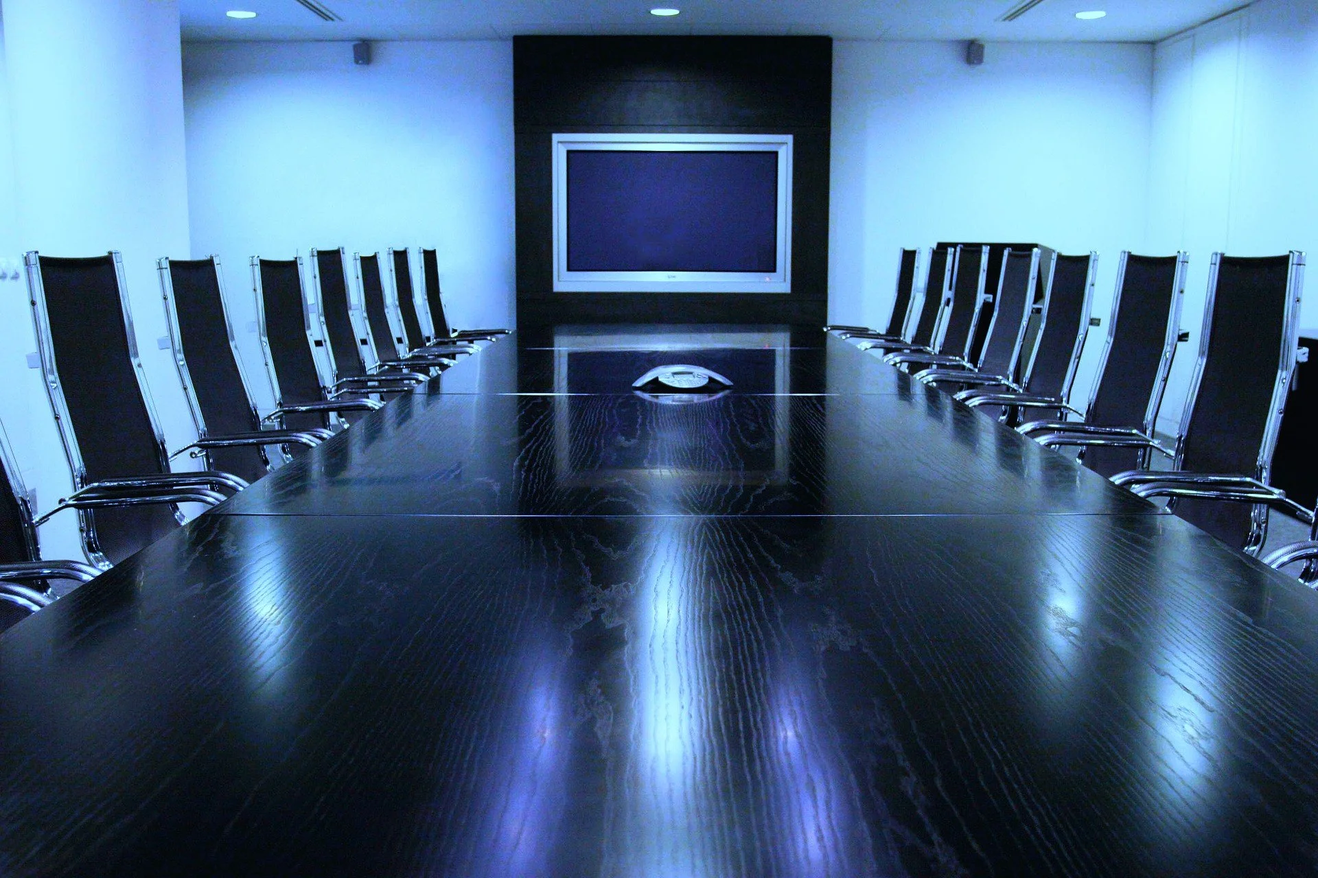 Blue-toned board room representing executive decision-making, organizational governance, and strategic advisory impact.