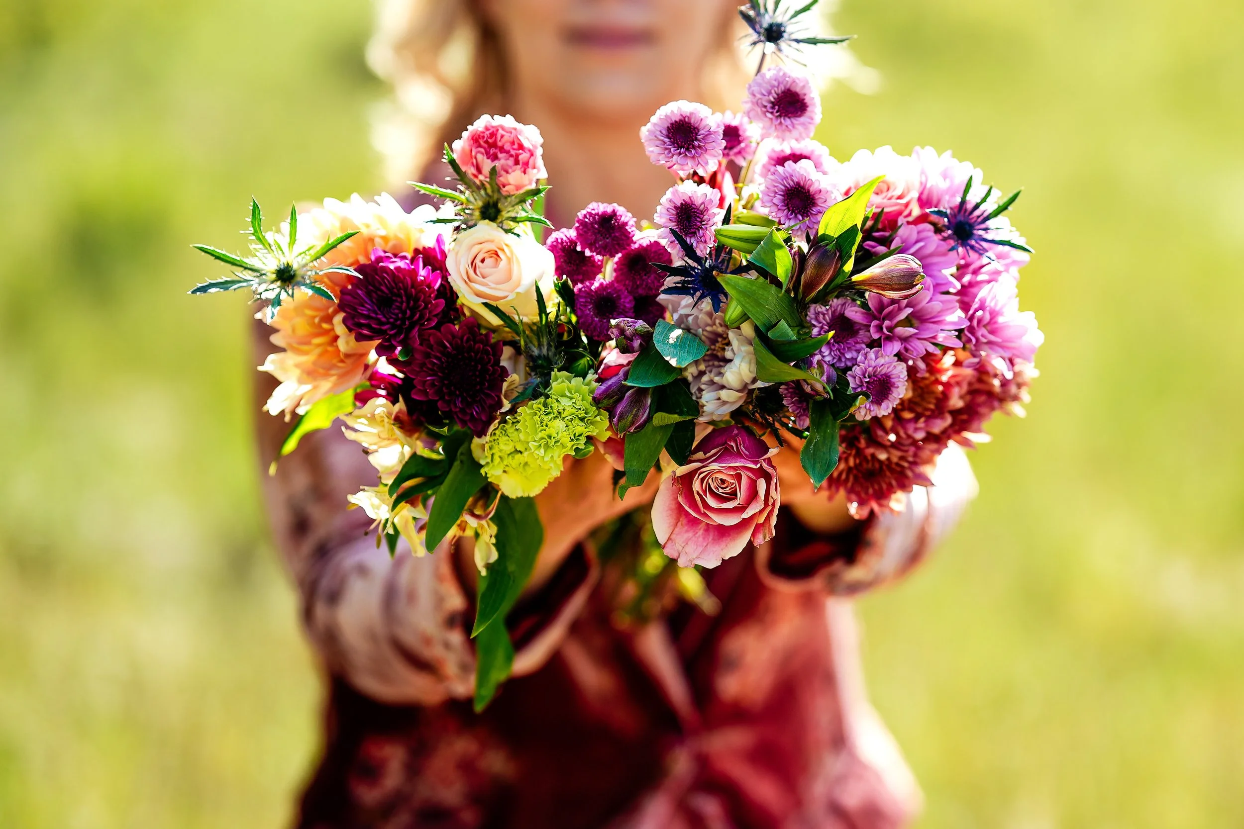 Karen Bommentre, LMFT, founder of Wild Gem Therapy, holding a bouquet of flowers