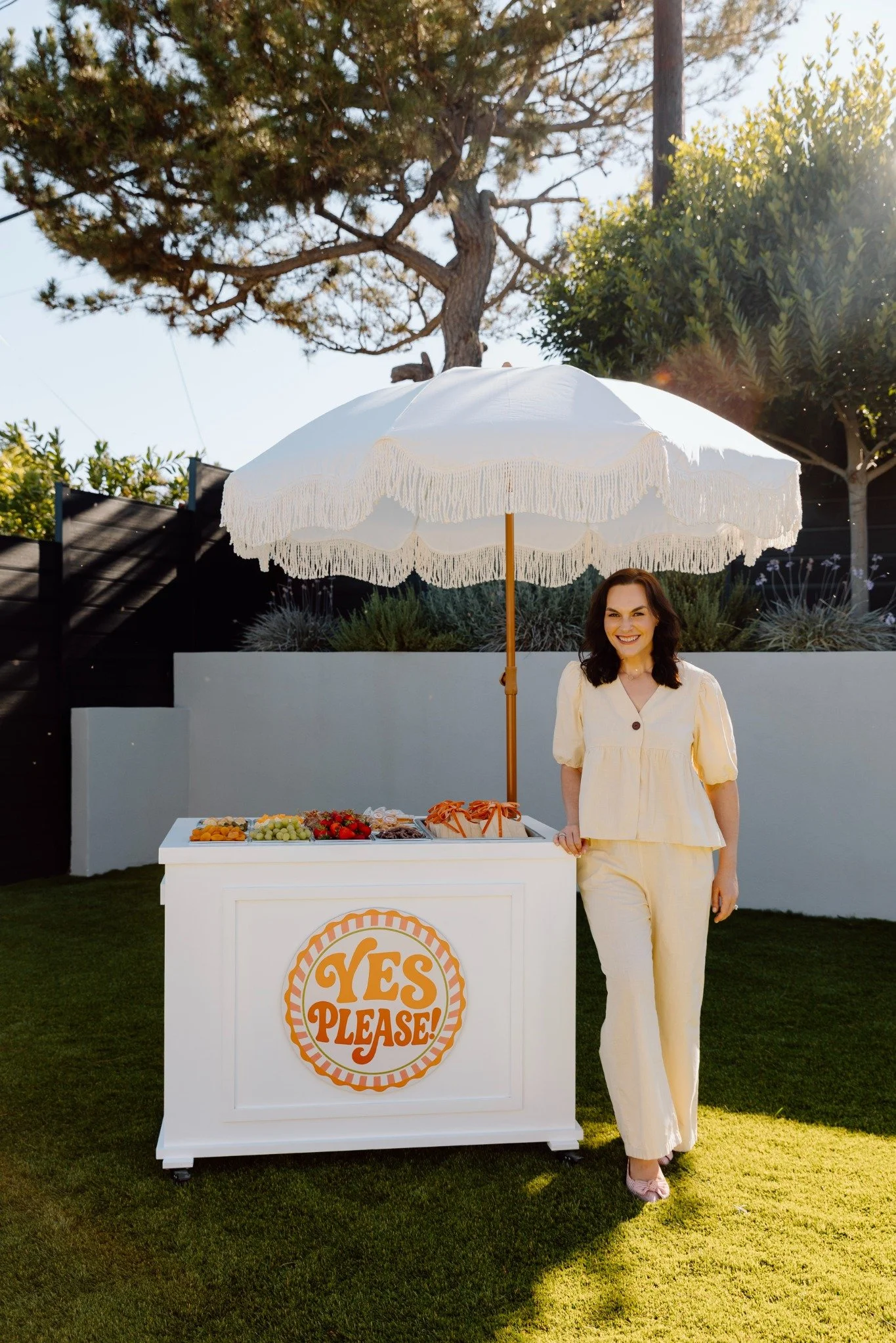 Lumi standing beside the fully styled Yes Please charcuterie cart