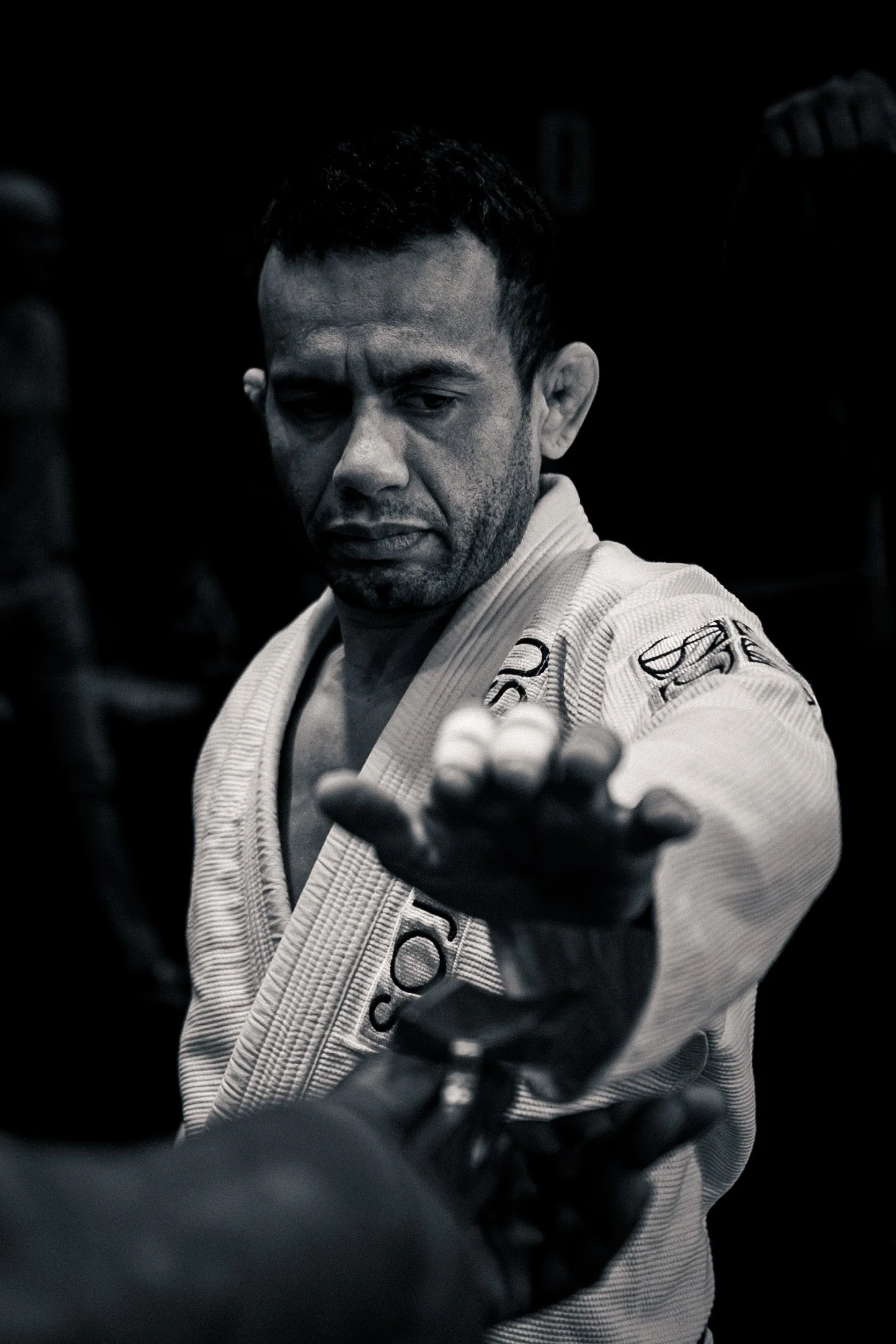 A male Brazilian Jiu-Jitsu practitioner wearing a gi , during his Gi inspection