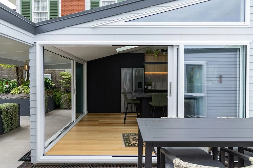 Modern renovated house in Auckland that blends old and new styles seamlessly, showcasing indoor-outdoor flow.