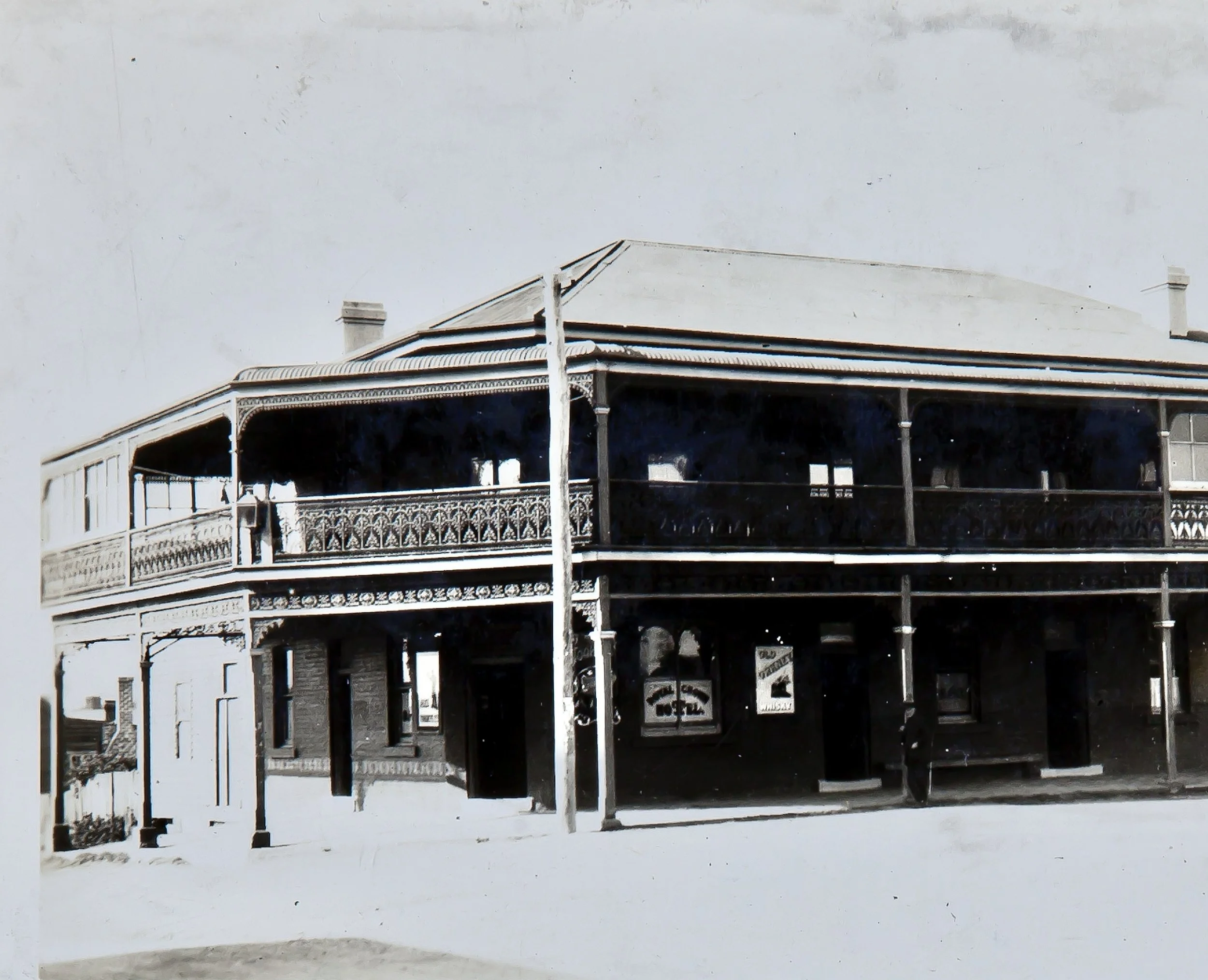 An unfinished building with metal framework and a roof, situated against a plain gray background.
