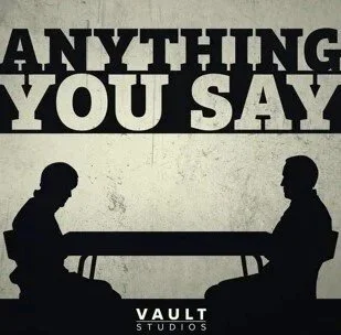 Silhouettes of two people sitting at a table facing each other with a speech bubble above them reading 'ANYTHING YOU SAY'. The logo 'Vault Studios' appears at the bottom.