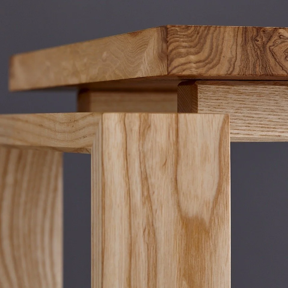 Close-up of wooden table legs and frame, showcasing natural wood grain and craftsmanship.