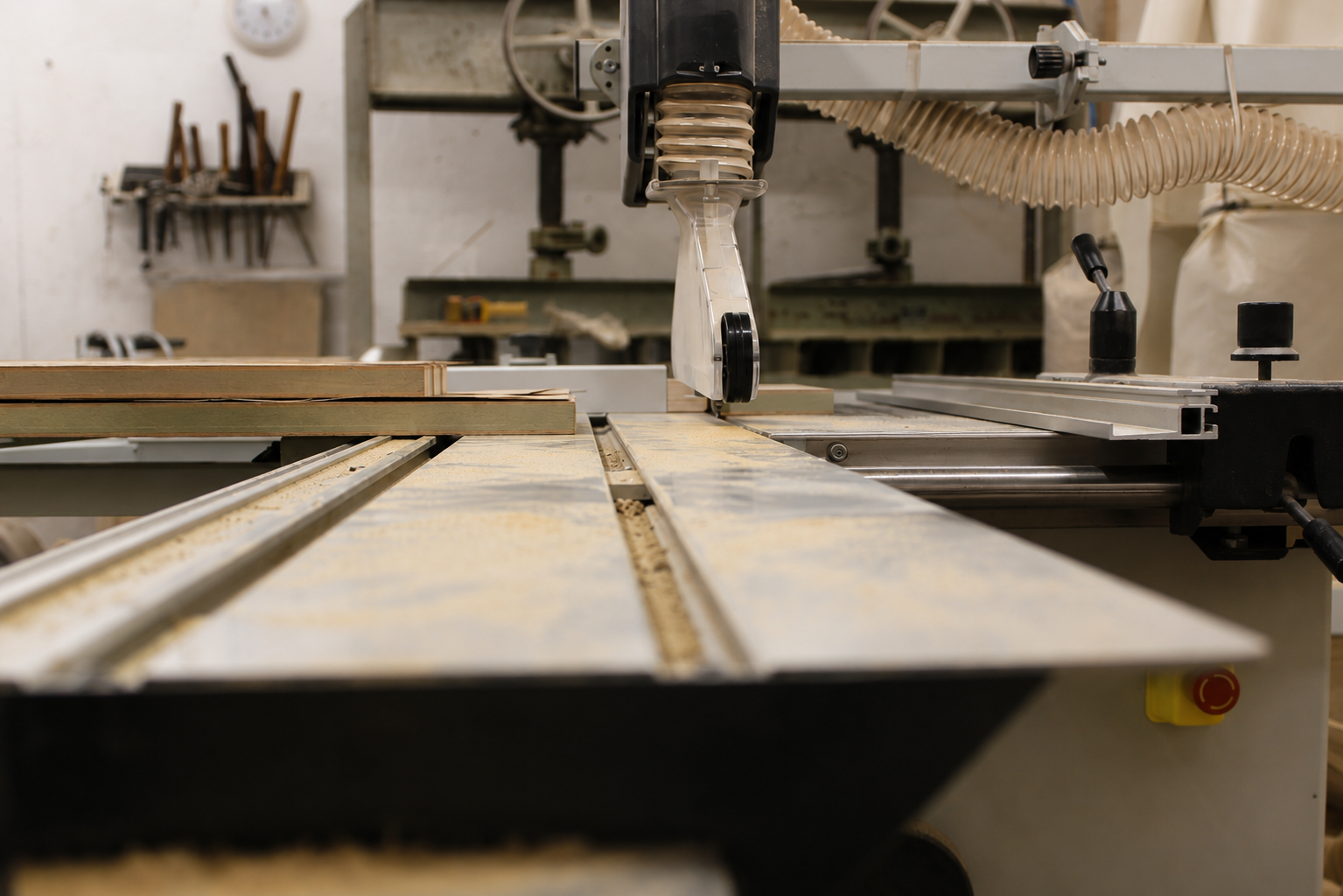 Image showing an honest worksop image. MDF on the panel saw ready to be cut. Veneer press and other tools in the background.