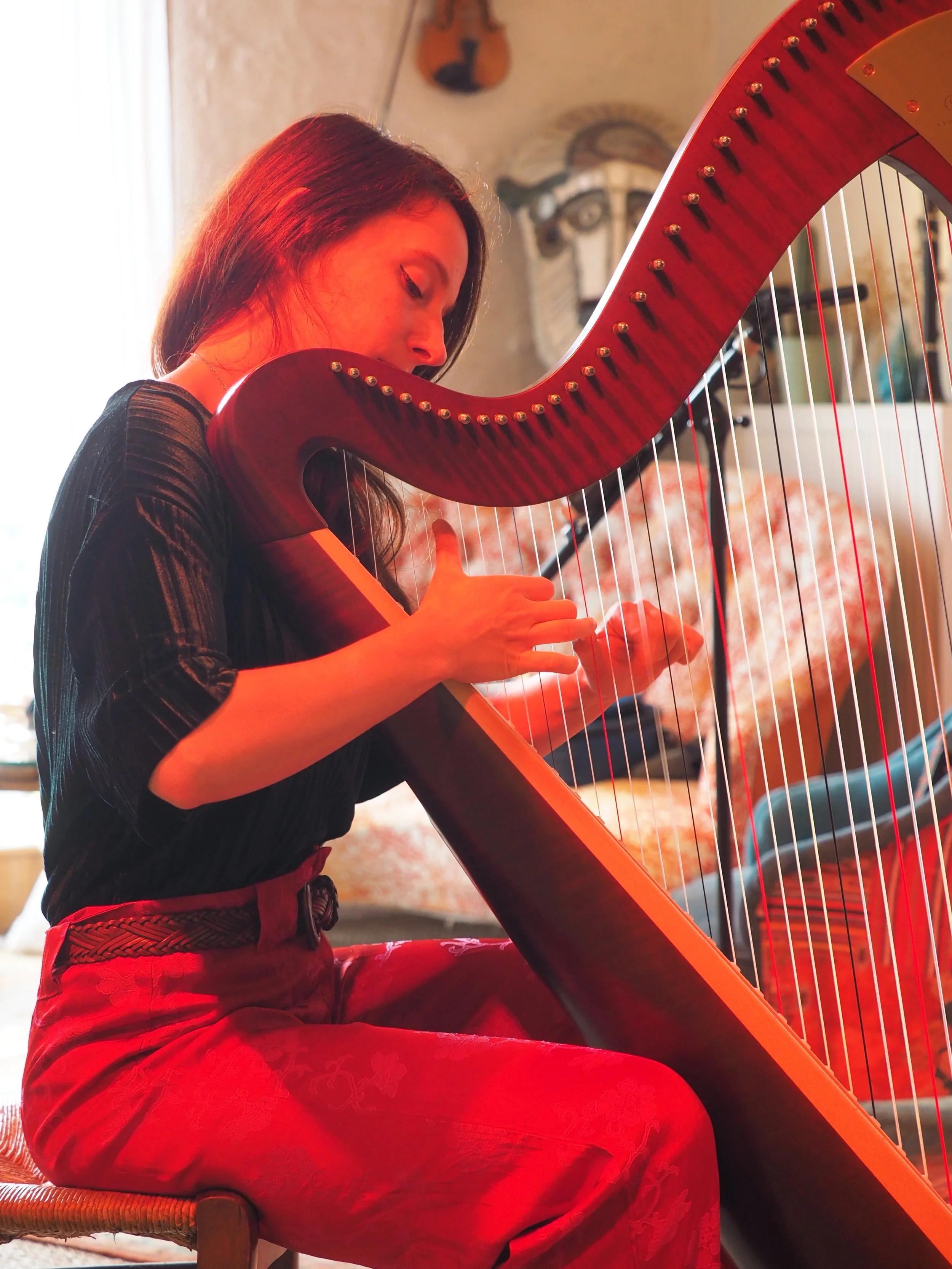Portrait à la harpe celtique d'Elise Esther en performance. Photo de Mariella Savannah