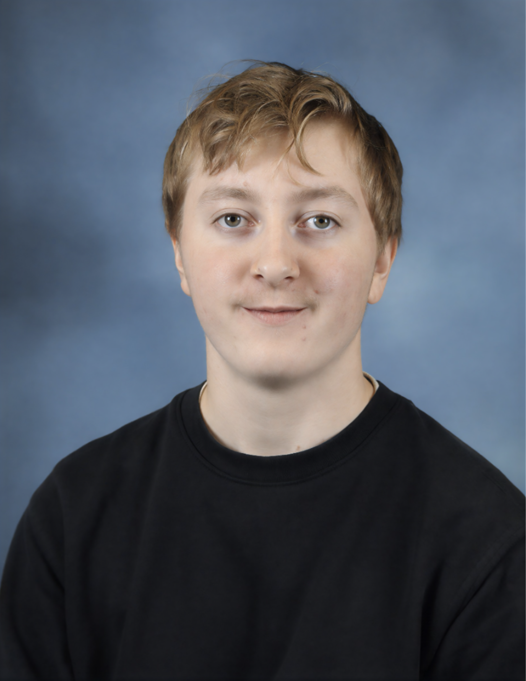 A young person with short, light brown hair and light skin wearing a black shirt against a blue background.
