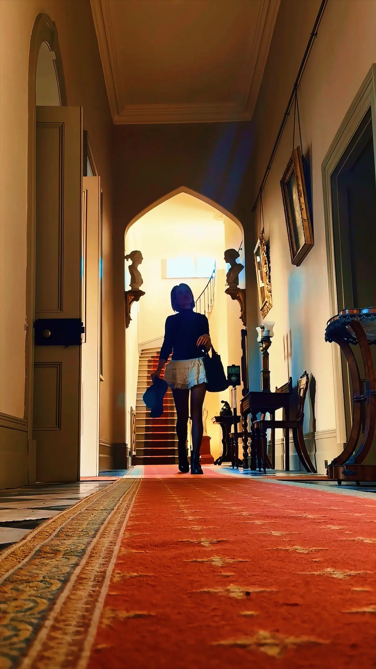 Rennie Holland, founder of High Net Woman walking in a beautiful estate home.