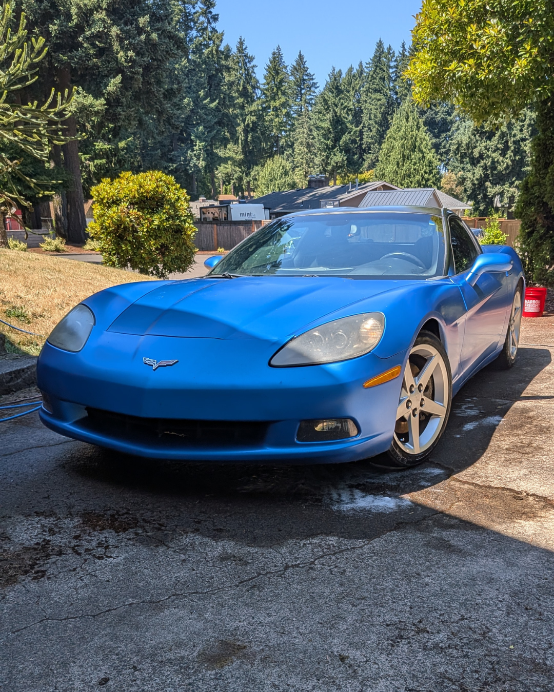 A blue Chevrolet Corvette sports car parked on a driveway.