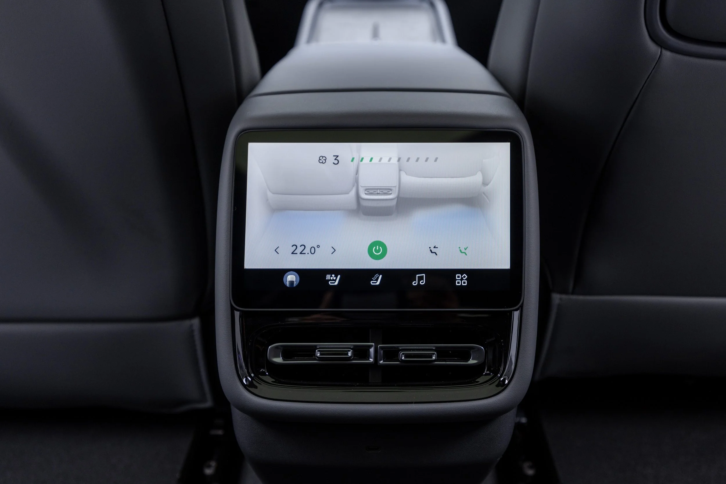 Inside view of a car showing a central touchscreen control panel with climate control settings and icons for seat heating, music, and ventilation. The display indicates a temperature of 22.0°C.