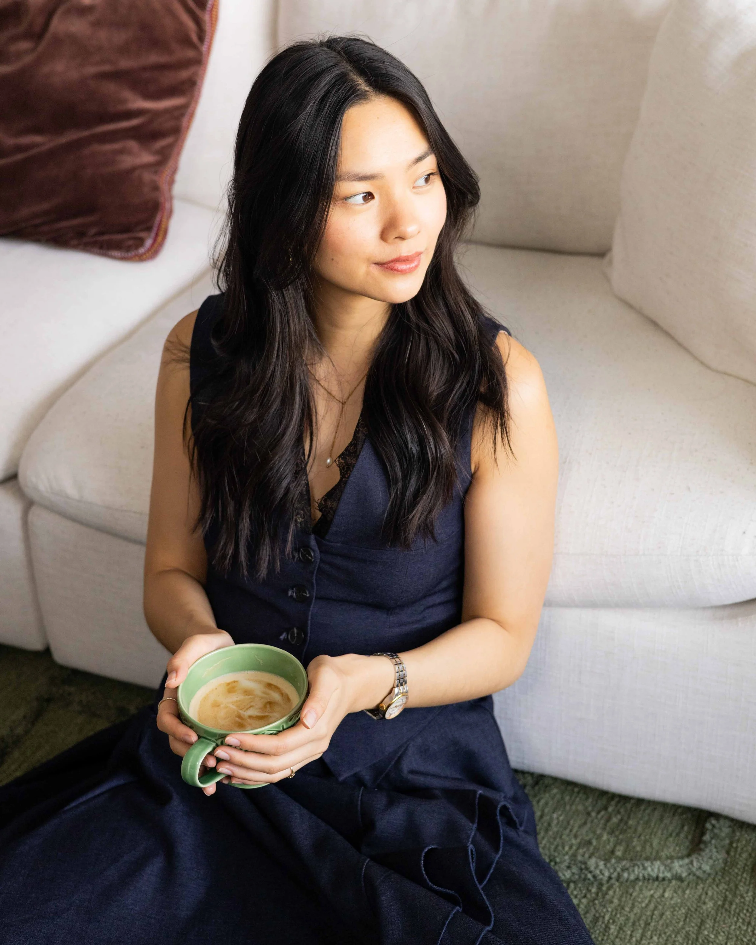 Olivia Lei sitting with a coffee, looking off to the side.