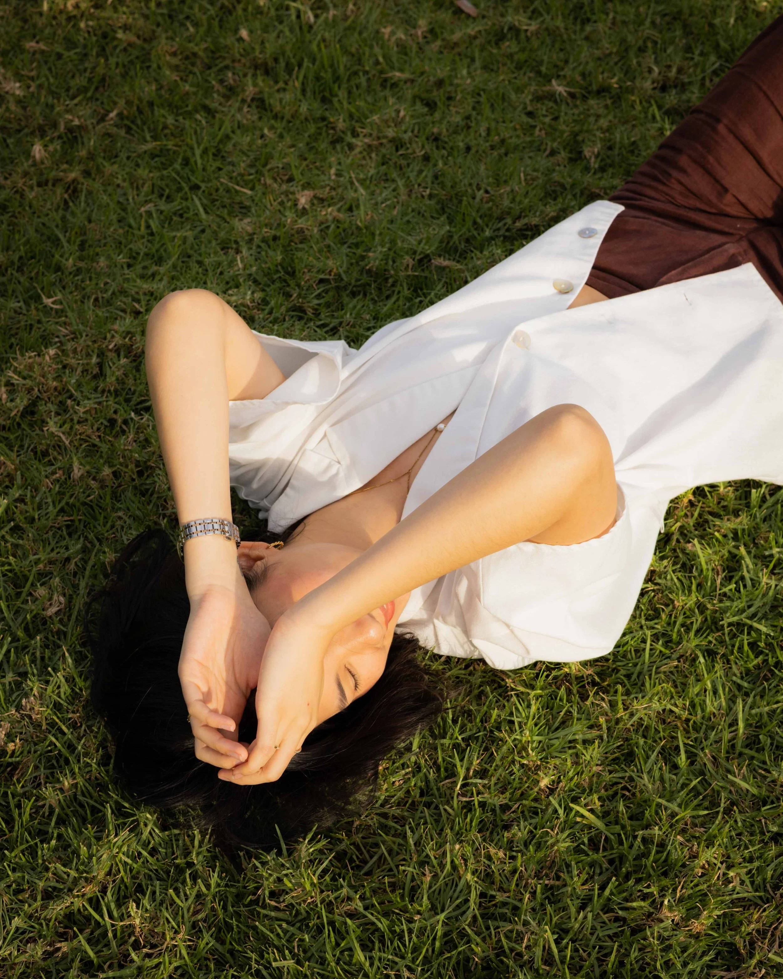 Olivia Lei lying in the grass, smiling.