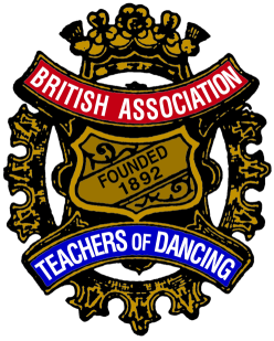 Emblem featuring a golden crest with black outlines, surrounded by ornamental designs, with a red banner reading 'British Association' at the top, a gold shield with 'Founded 1892' in the center, and a blue banner at the bottom reading 'Teachers of Dancing'.