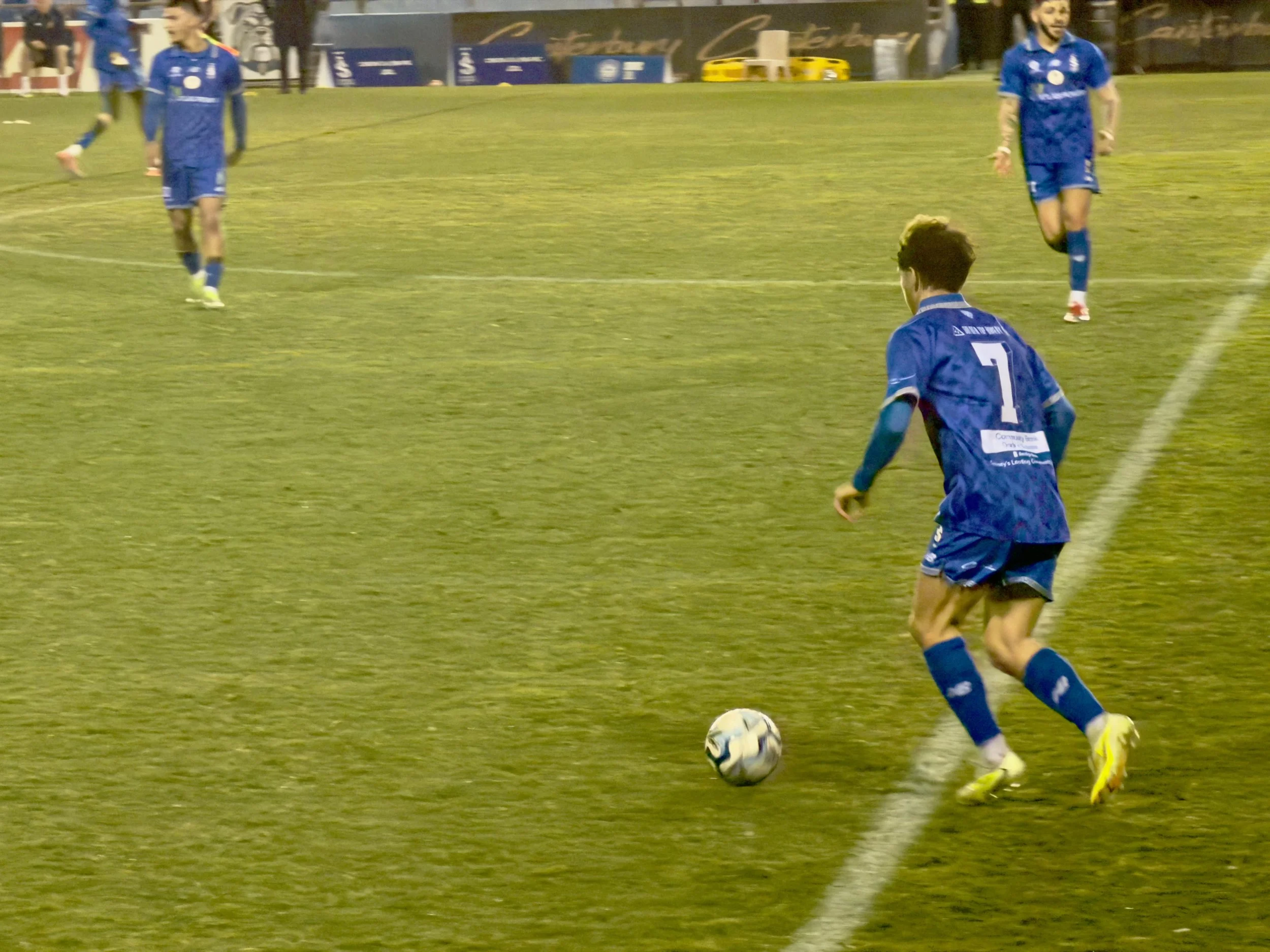 Sydney Olympic number seven runs onto the ball near the right touchline as teammates look on.