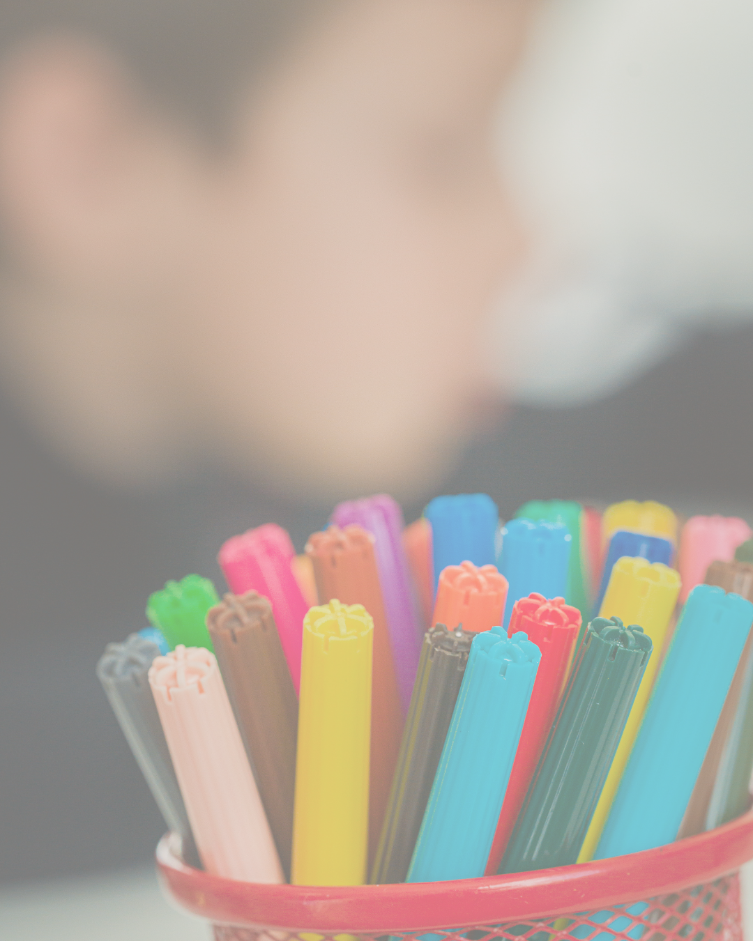 Colorful plastic straws in a red mesh cup.