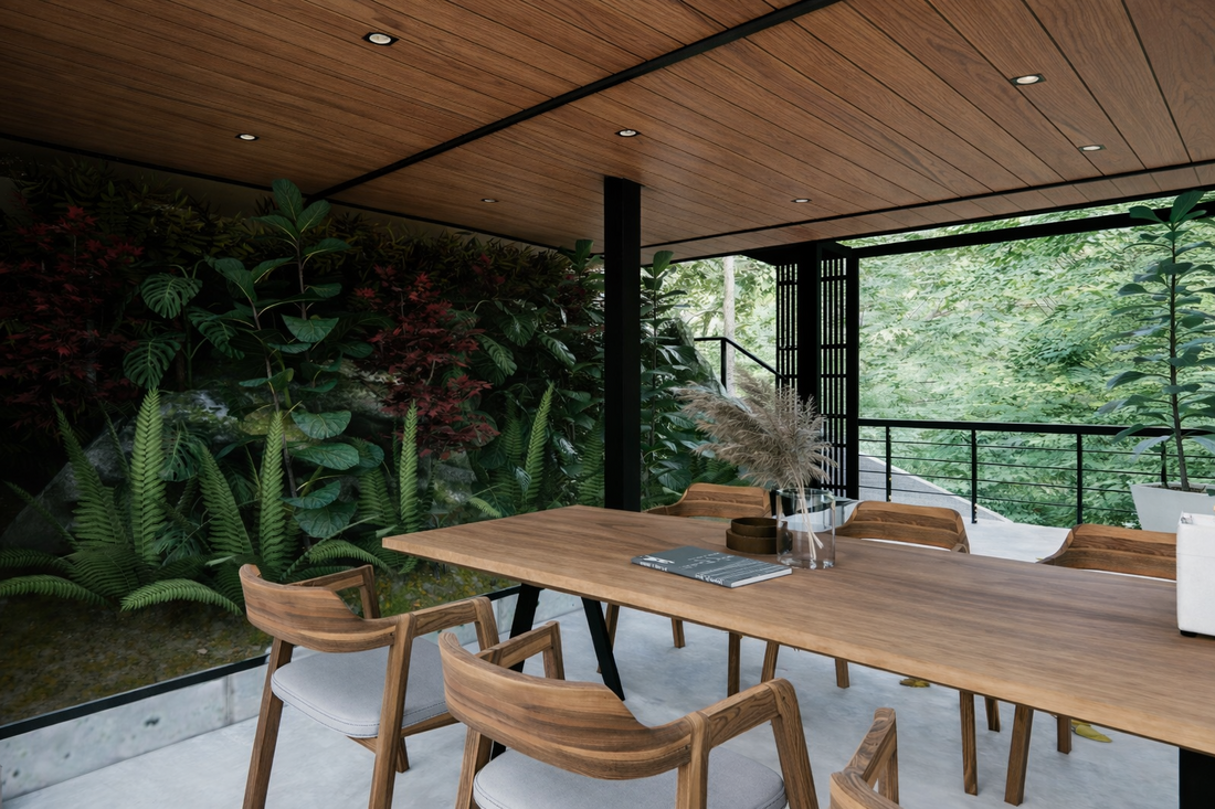 Modern indoor dining space with a large wooden table, upholstered chairs, and a wall of greenery with ferns and plants.